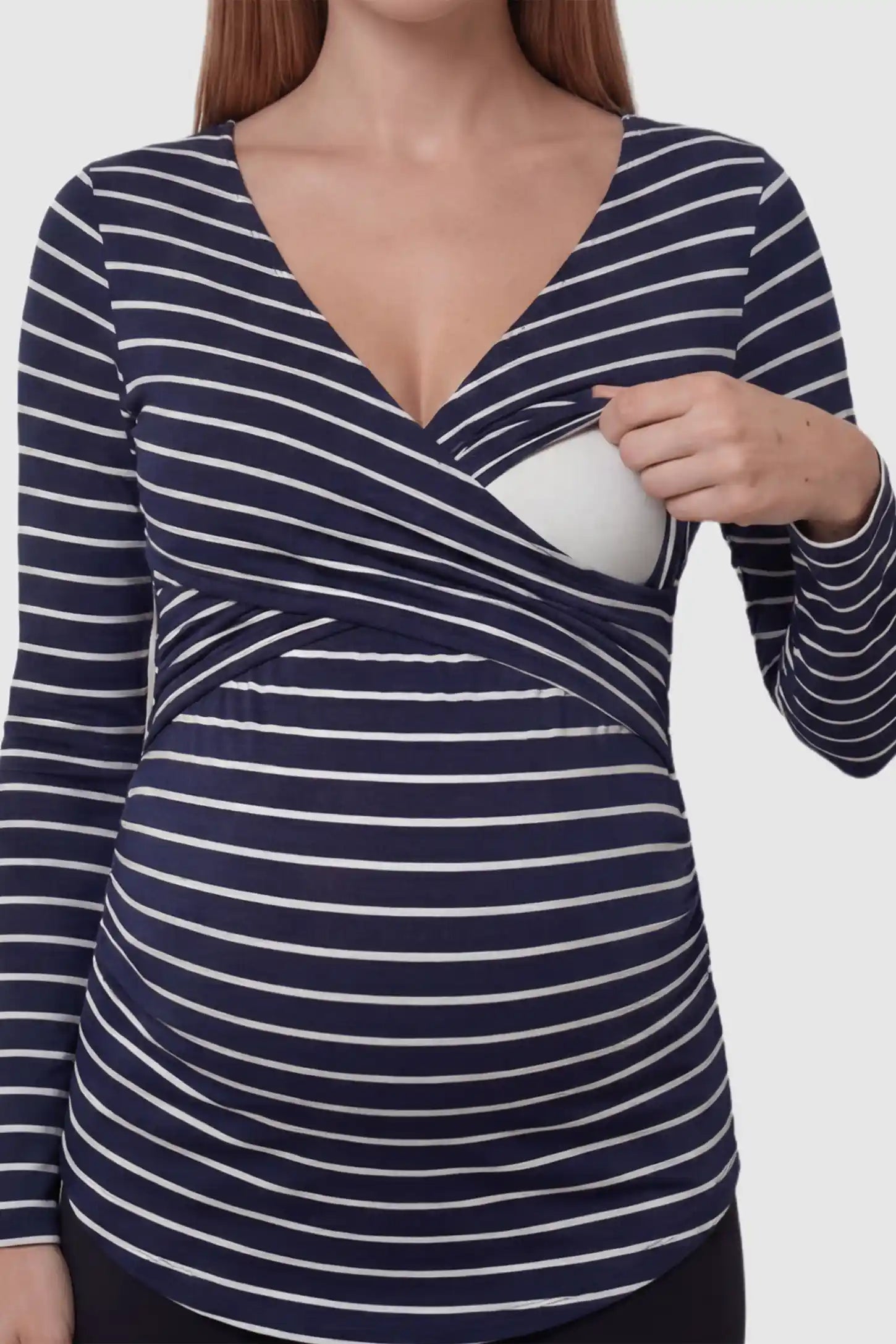 Striped Wrap Front Maternity & Nursing Top Striped Wrap Front Nursing Top in navy blue with crossover neckline on a pregnant model showing nursing access.