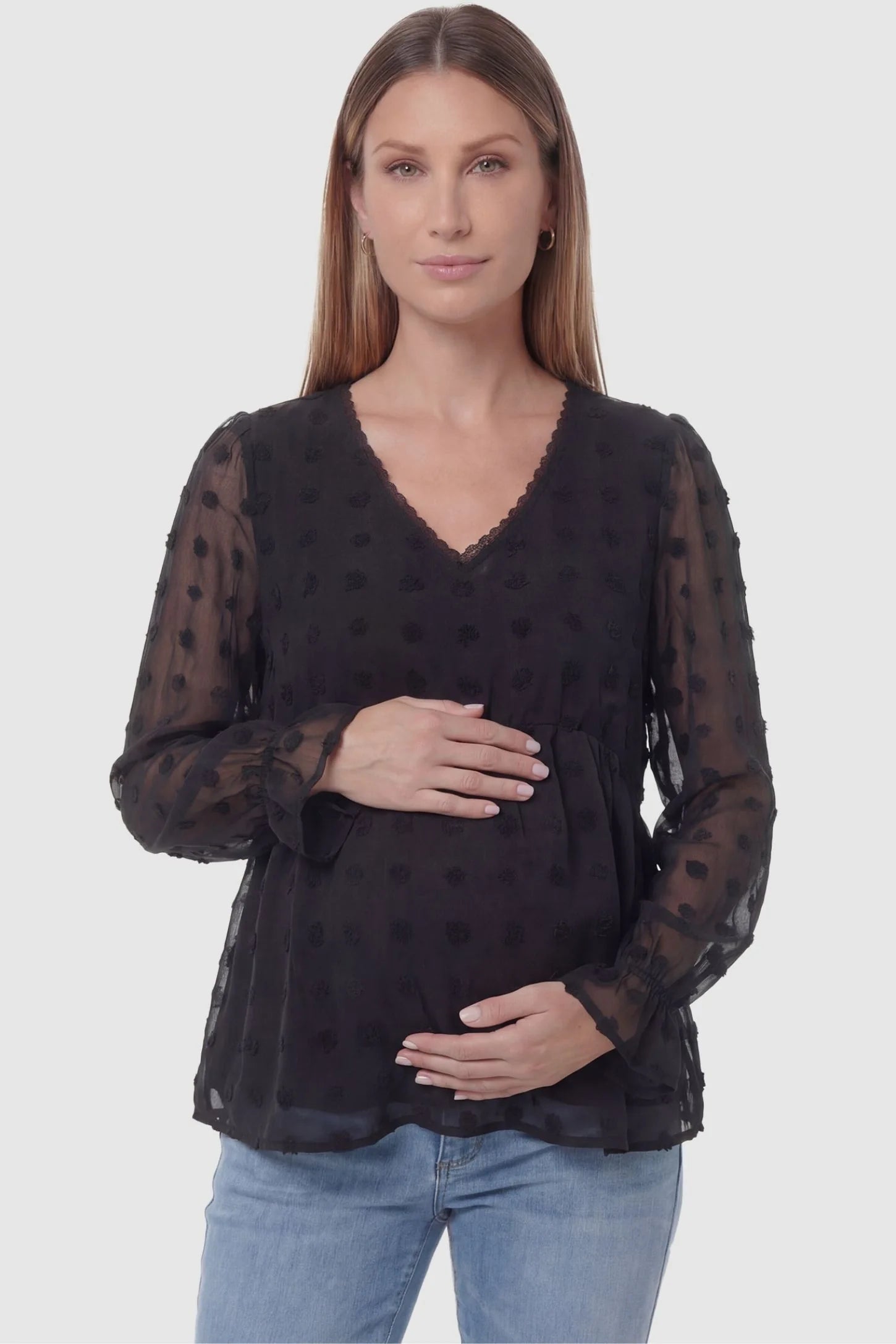 Swiss Dot Sheer Empire Waist Maternity Top in black featuring textured swiss dots, front view on a pregnant model.