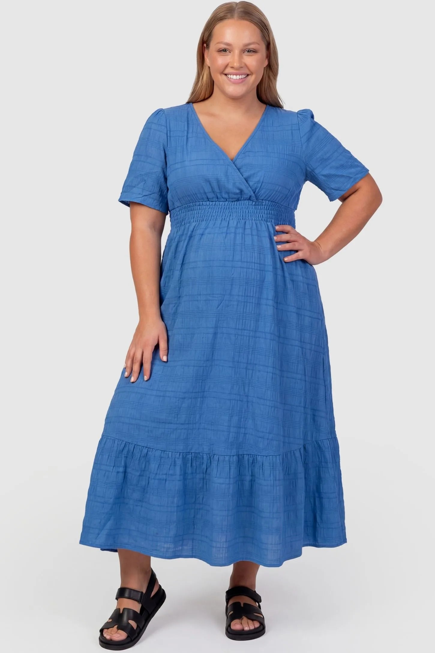 Textured Knit Butterfly Sleeve Maternity Midi Dress Textured Knit Butterfly Sleeve Midi Dress in Blue featuring feminine short butterfly sleeves on a plus-size pregnant model, front view.