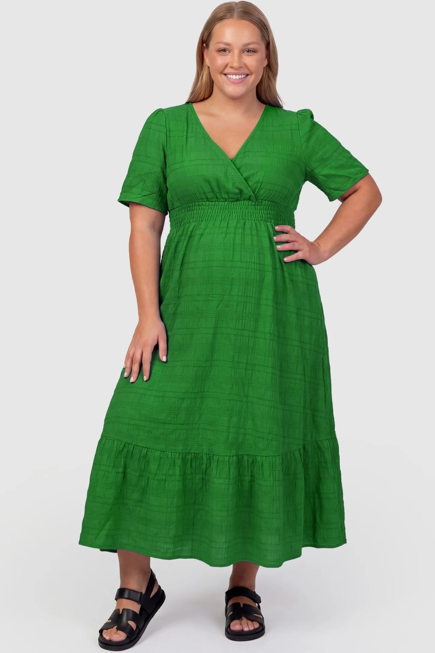Textured Knit Butterfly Sleeve Maternity Midi Dress Textured Knit Butterfly Sleeve Midi Dress in Green featuring feminine short butterfly sleeves on a plus-size pregnant model, front view.