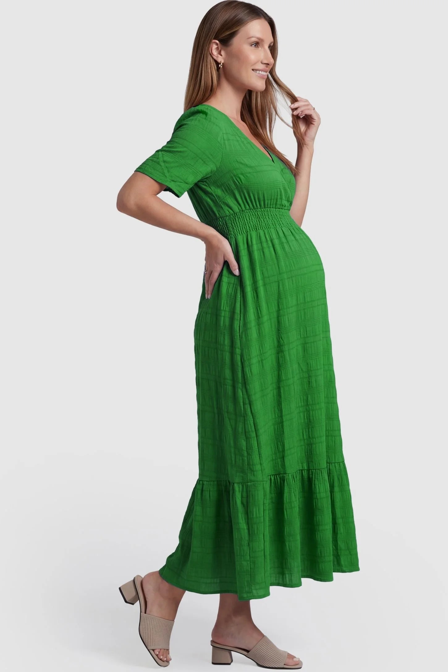Textured Knit Butterfly Sleeve Maternity Midi Dress Textured Knit Butterfly Sleeve Midi Dress in Green featuring feminine short butterfly sleeves on a pregnant model, side view.