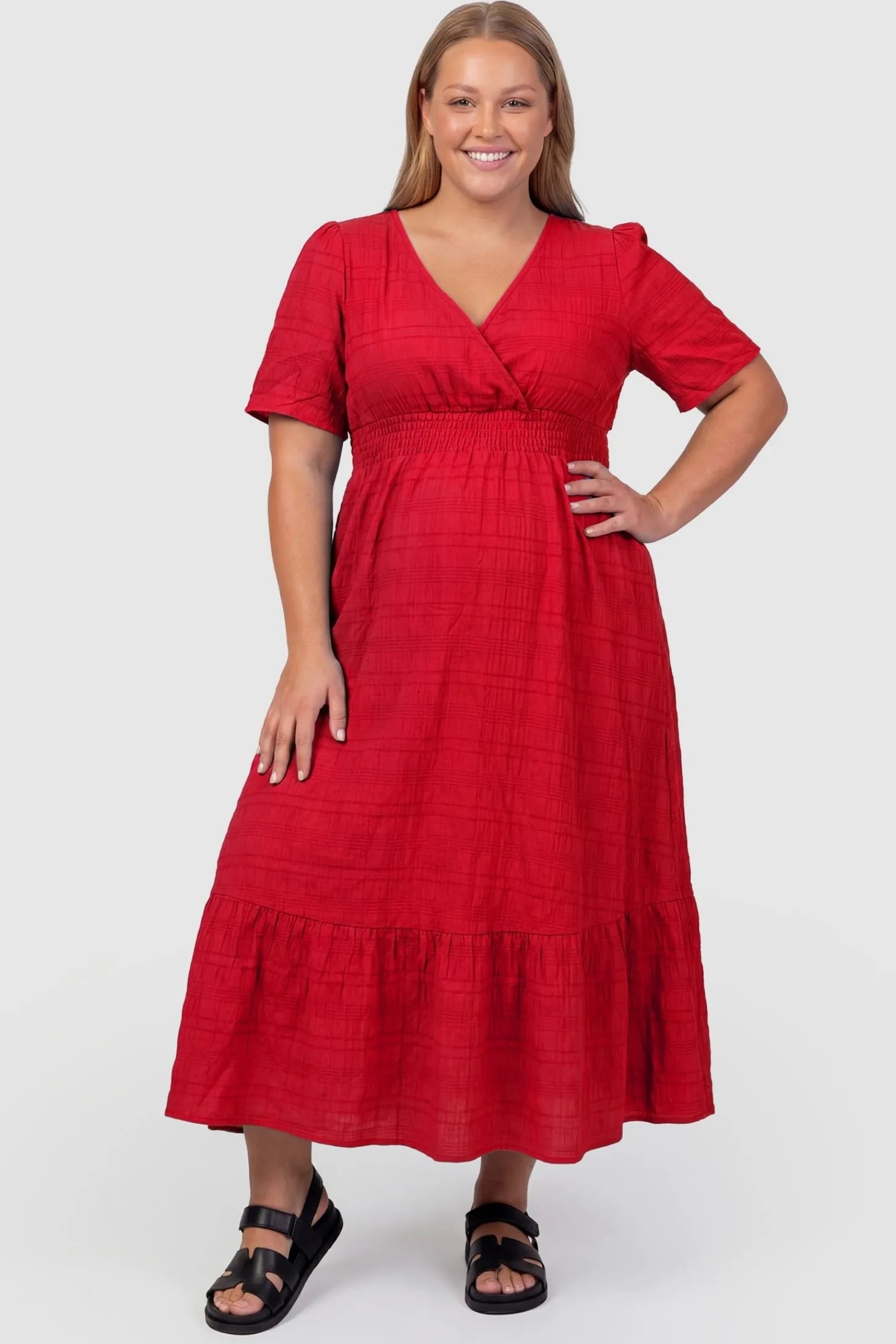 Textured Knit Butterfly Sleeve Maternity Midi Dress Textured Knit Butterfly Sleeve Midi Dress in Red featuring feminine short butterfly sleeves on a plus-size pregnant model, front view.
