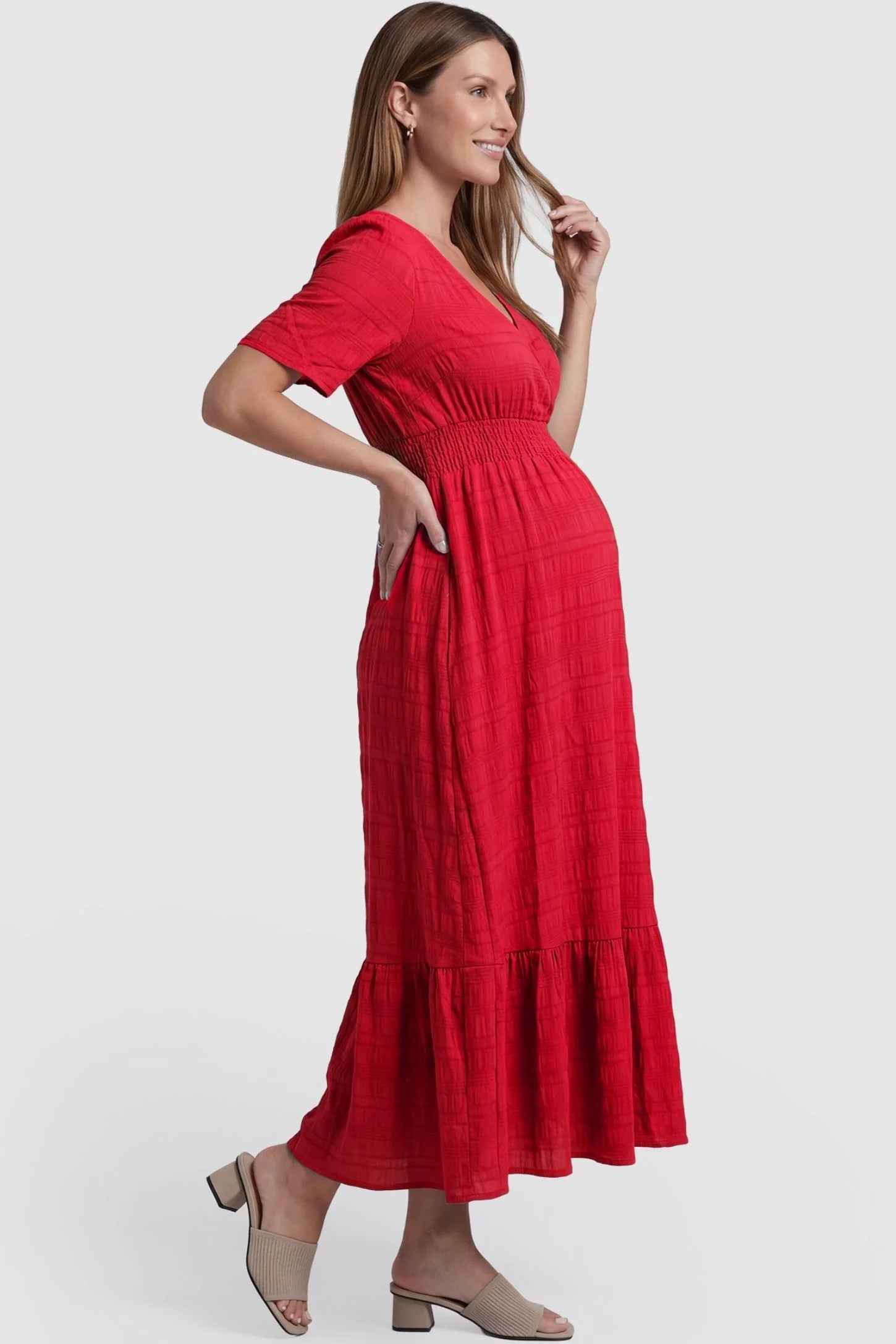 Textured Knit Butterfly Sleeve Maternity Midi Dress Textured Knit Butterfly Sleeve Midi Dress in Red featuring feminine short butterfly sleeves on a pregnant model, side view.