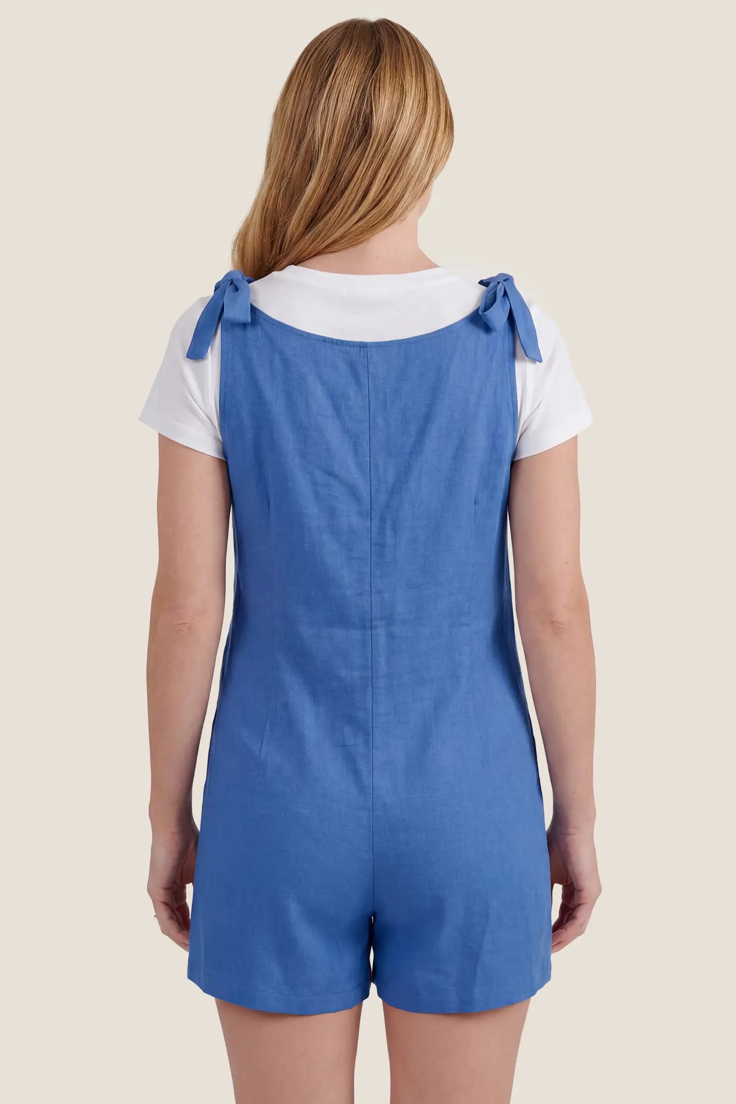Tie-Strap Sleeveless Pocketed Maternity Romper Back view of the blue Tie-Strap Sleeveless Pocketed Maternity Romper with tie shoulder straps and a relaxed fit.