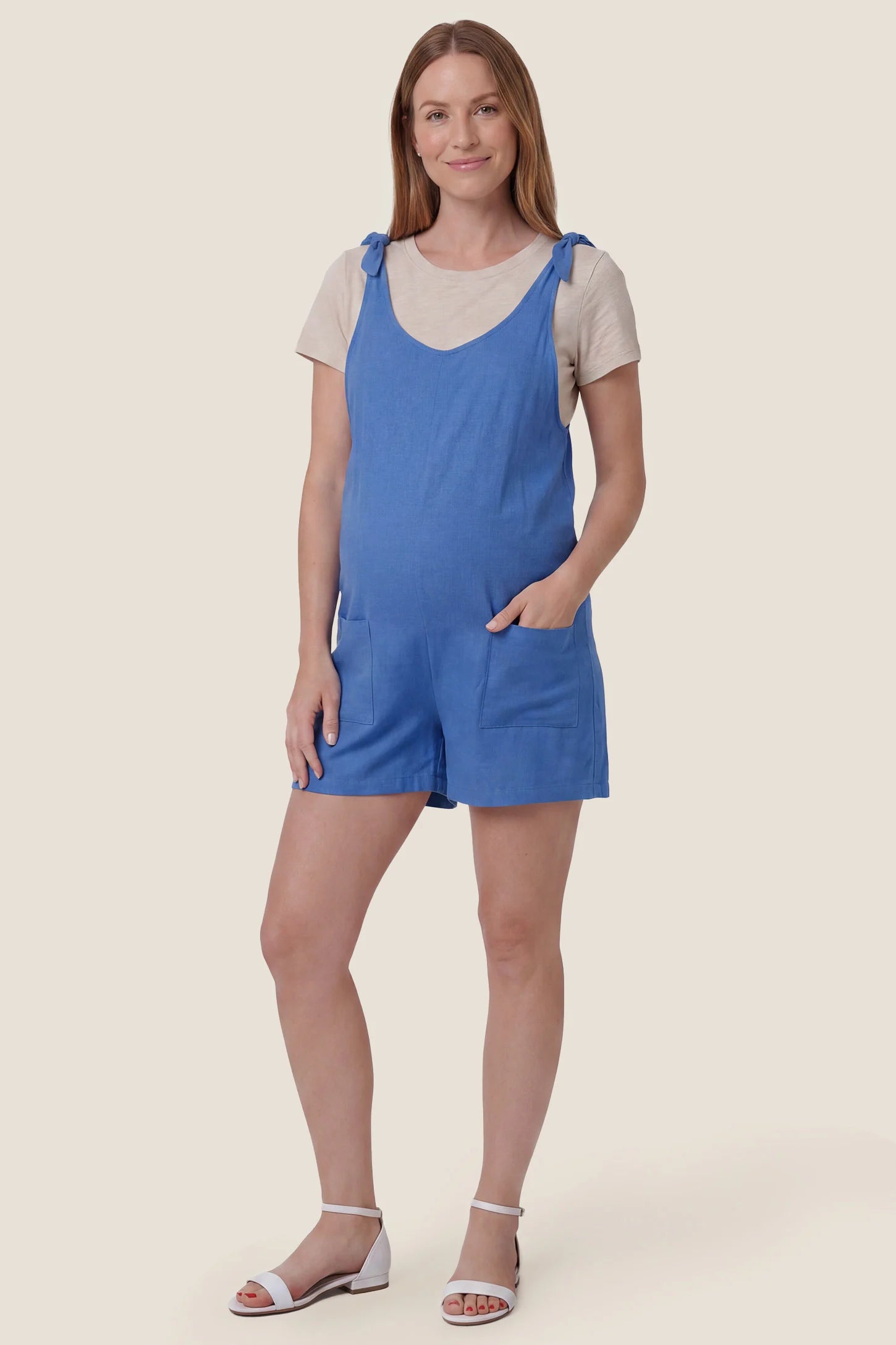 Tie-Strap Sleeveless Pocketed Maternity Romper Full body view of the blue Tie-Strap Sleeveless Pocketed Maternity Romper styled for casual everyday maternity wear.