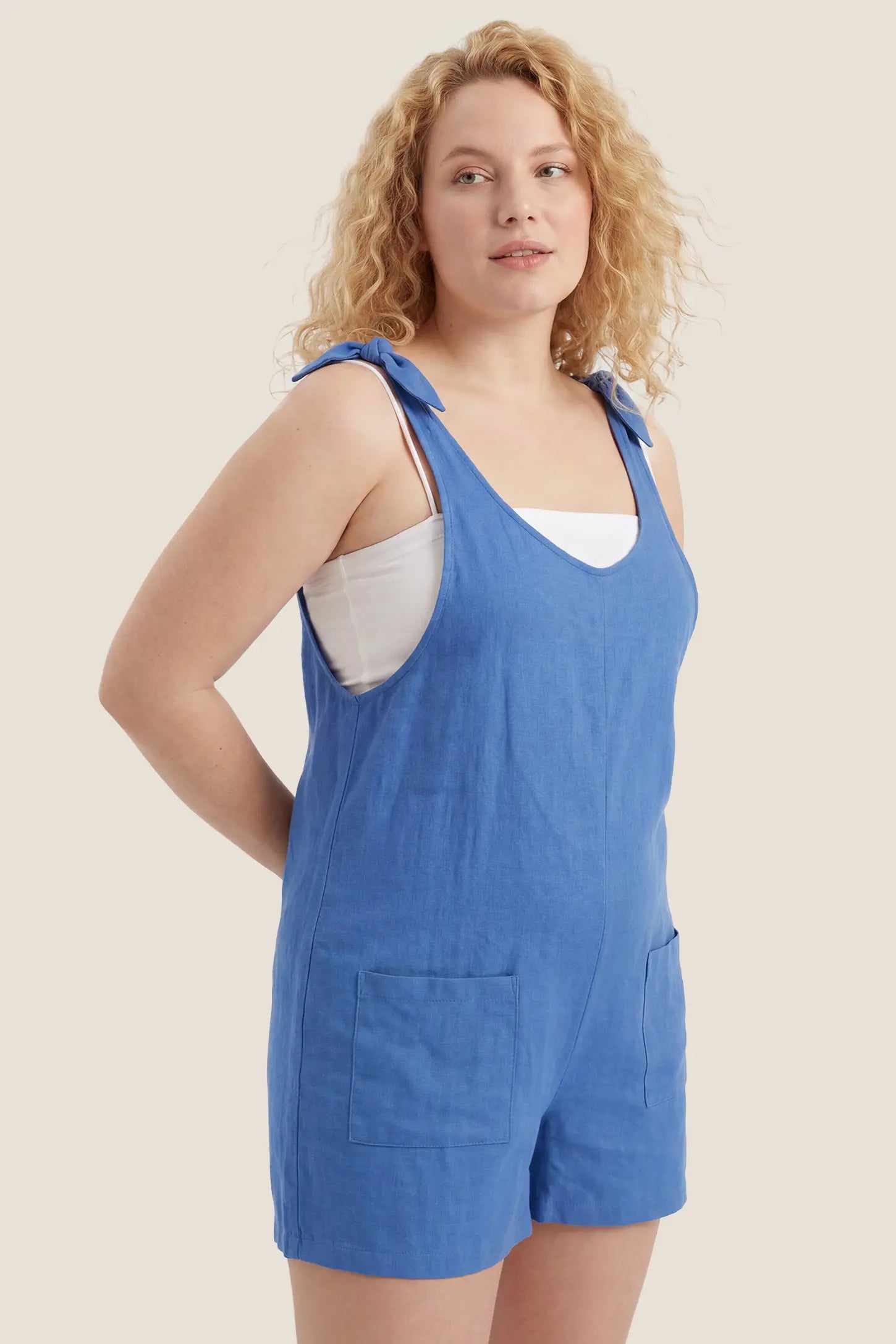 Tie-Strap Sleeveless Pocketed Maternity Romper Postpartum hero view of the blue Tie-Strap Sleeveless Pocketed Maternity Romper with a flattering relaxed silhouette.