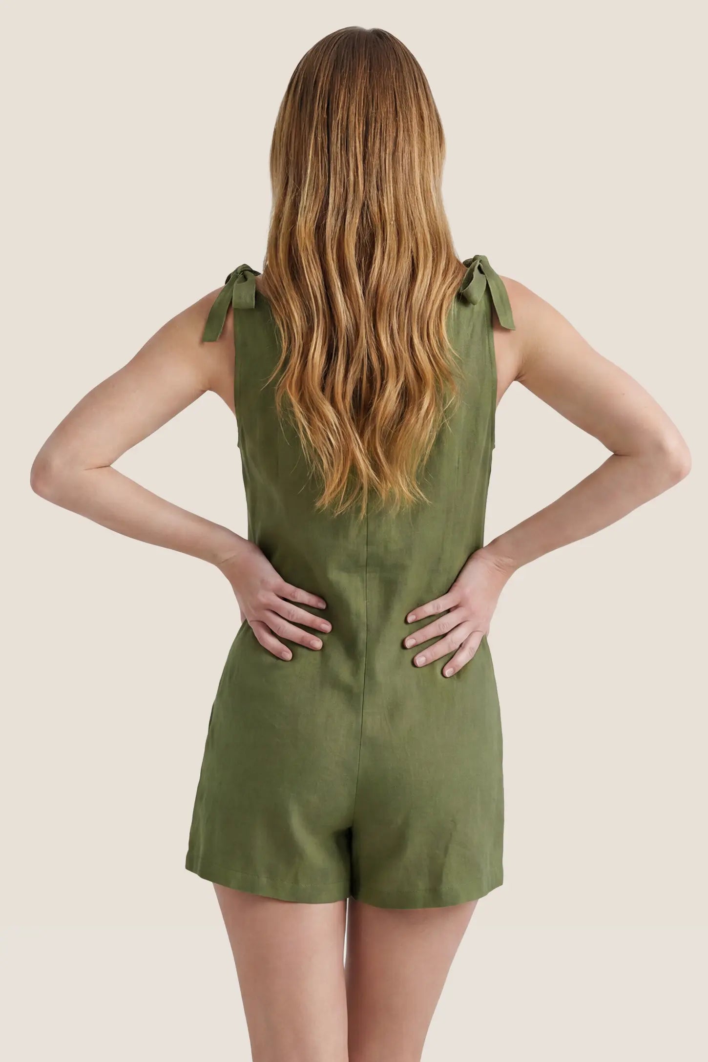 Tie-Strap Sleeveless Pocketed Maternity Romper Back view of the green Tie-Strap Sleeveless Pocketed Maternity Romper featuring tied shoulder straps and a relaxed silhouette.