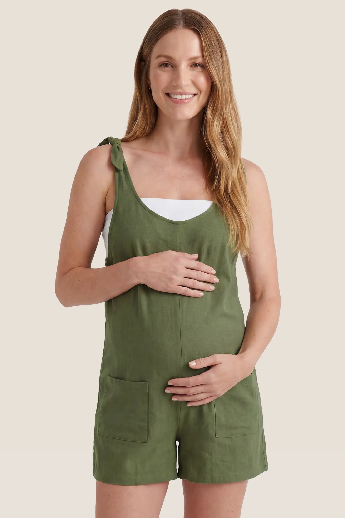 Front studio view of the green Tie-Strap Sleeveless Pocketed Maternity Romper with a flattering maternity fit.