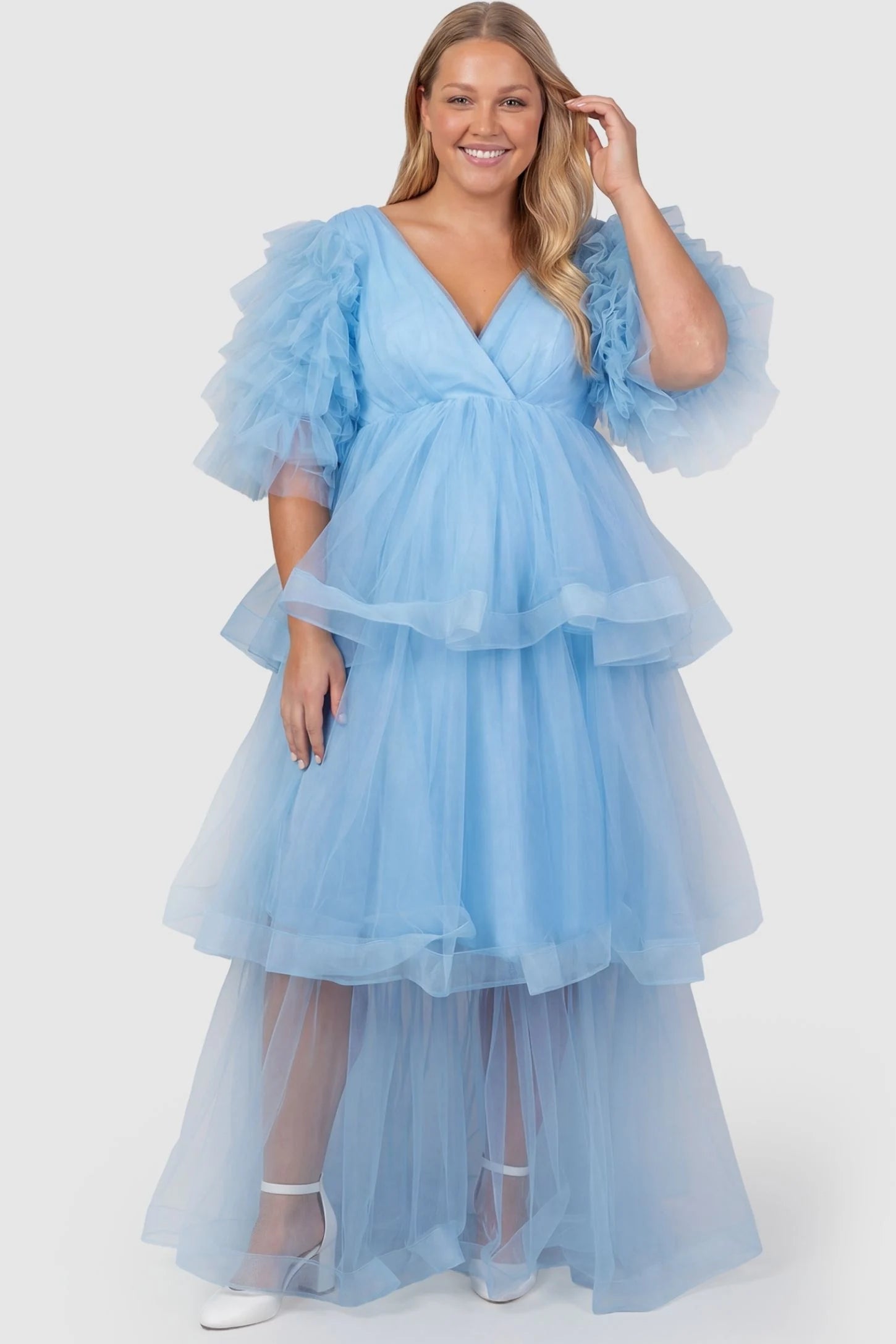 Tiered Ruffled Tulle Flutter Sleeve Maternity Maxi Gown Tiered Ruffled Tulle Flutter Sleeve Maternity Maxi Gown in Blue featuring ruffled flutter sleeves on plus size pregnant model, front view.