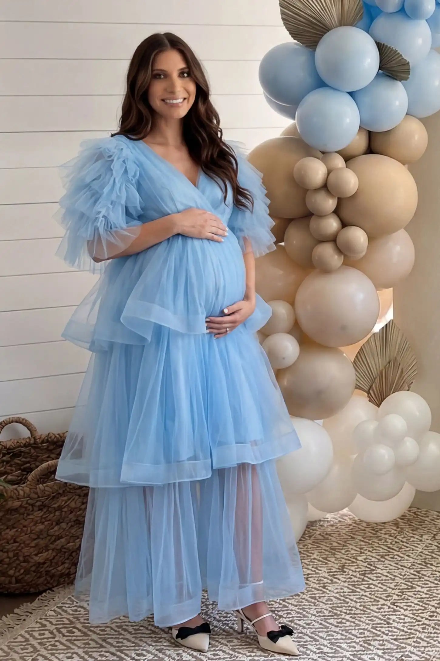 Tiered Ruffled Tulle Flutter Sleeve Maternity Maxi Gown Tiered Ruffled Tulle Flutter Sleeve Maternity Maxi Gown in Blue with statement flutter sleeves on pregnant model at baby shower, front view.