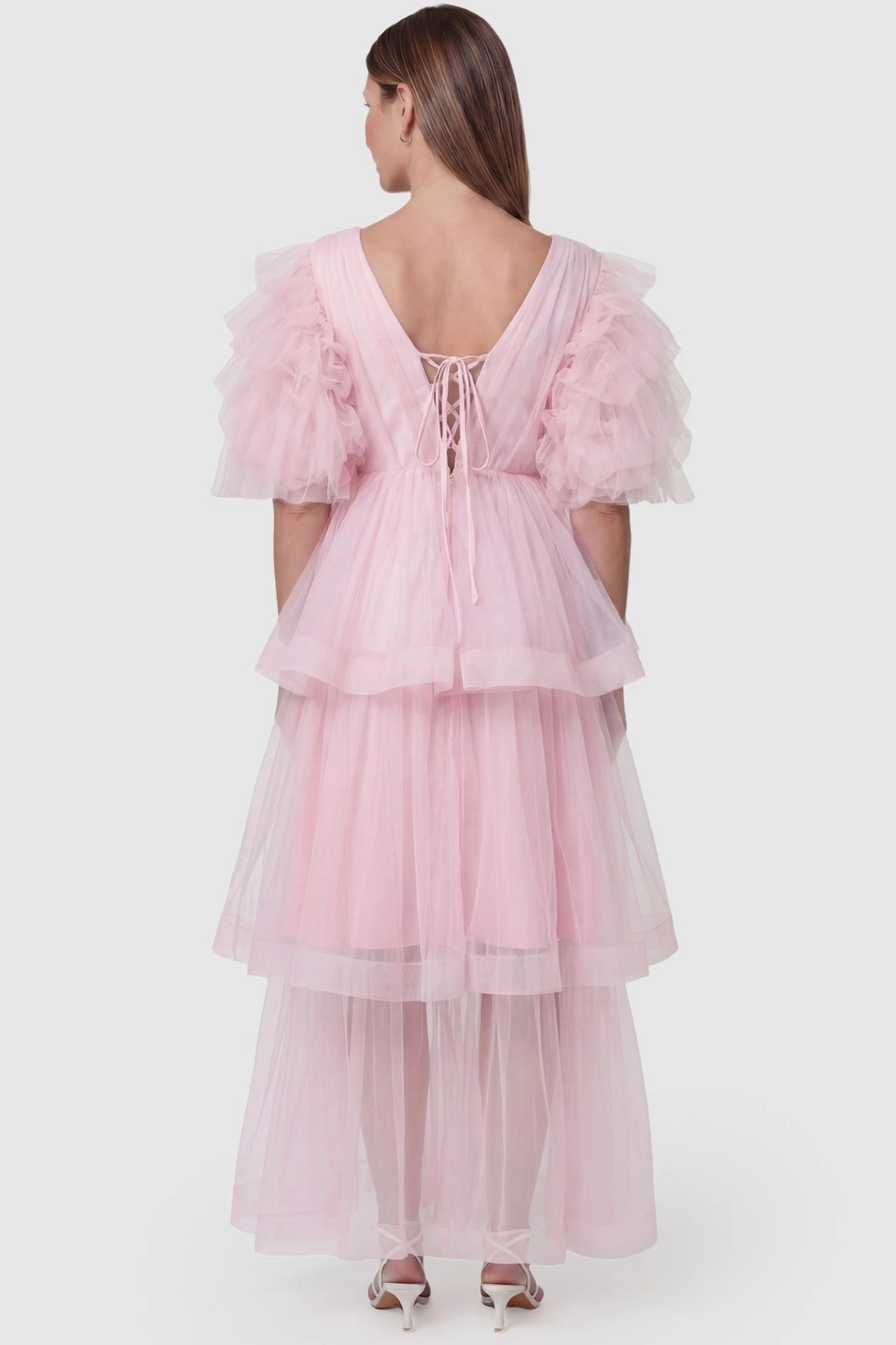 Tiered Ruffled Tulle Flutter Sleeve Maternity Maxi Gown Tiered Ruffled Tulle Flutter Sleeve Maternity Maxi Gown in Pink featuring lace-up back detail on pregnant model, back view.