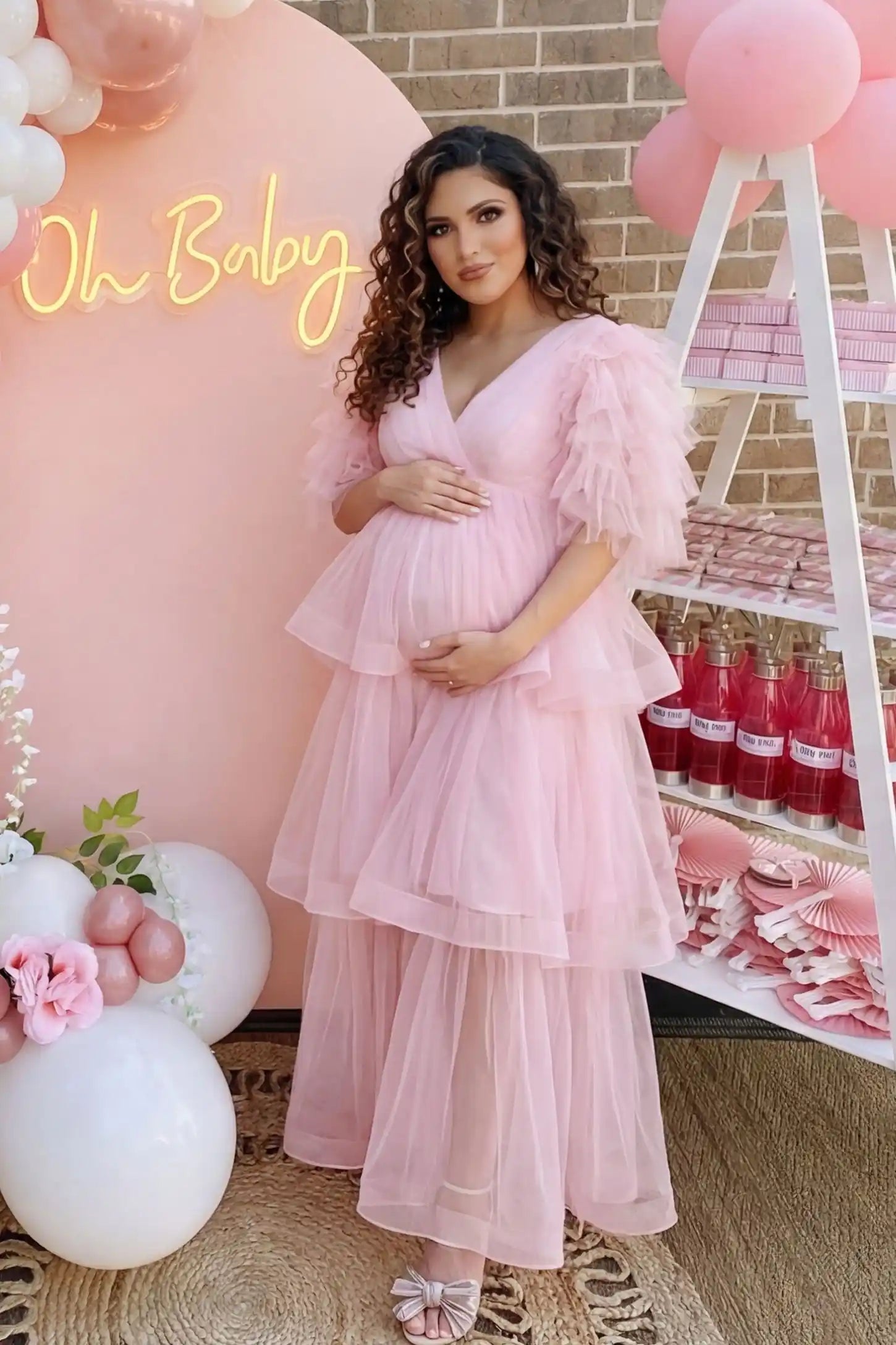 Tiered Ruffled Tulle Flutter Sleeve Maternity Maxi Gown Tiered Ruffled Tulle Flutter Sleeve Maternity Maxi Gown in Pink with statement flutter sleeves on pregnant model at baby shower, front view.