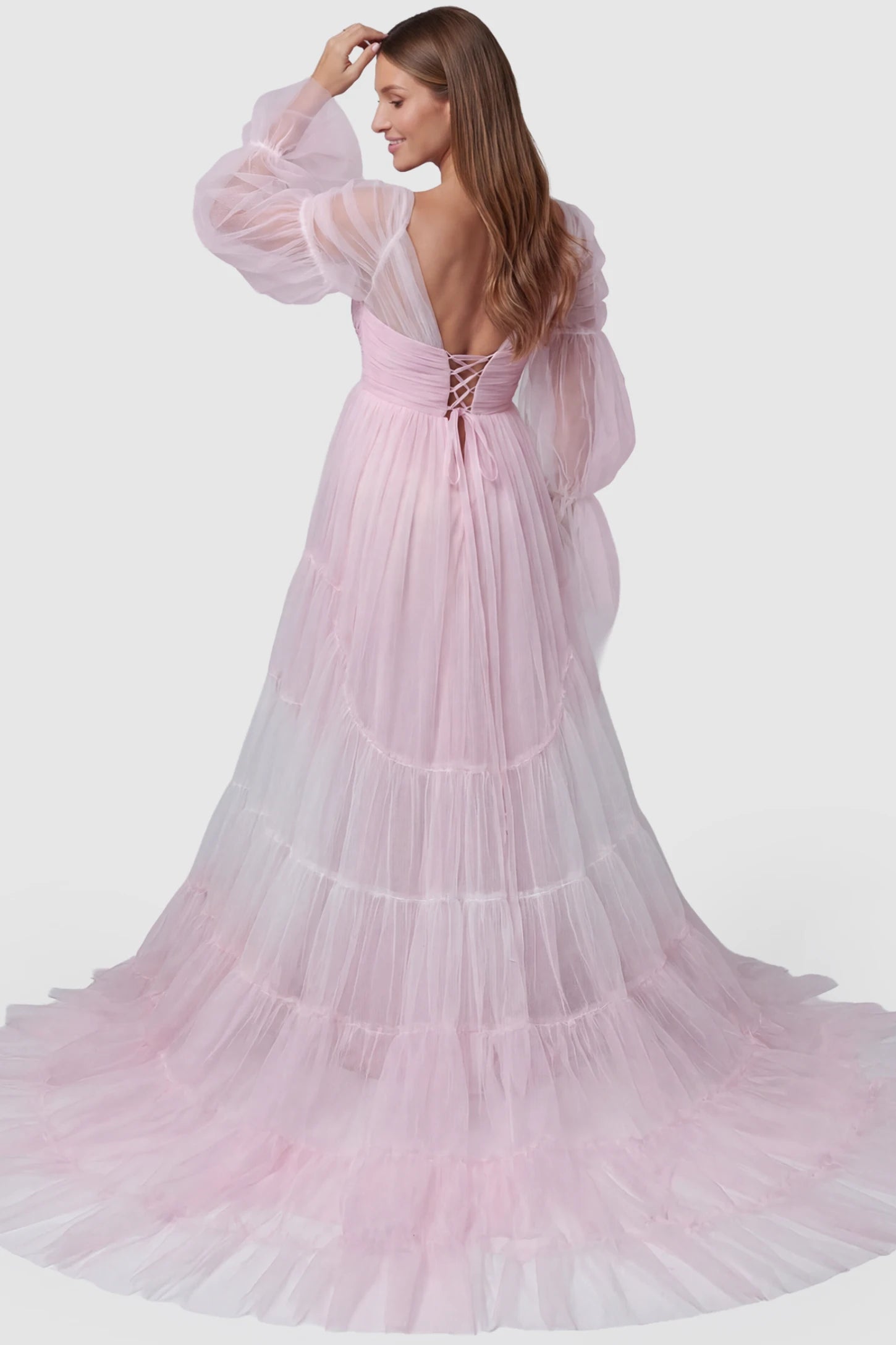 Tiered Tulle Long Sleeve Maternity Photoshoot Gown Tiered Tulle Long Sleeve Maternity photoshoot Gown in Pink featuring a lace-up corset back and floor-length skirt on a model, back view.