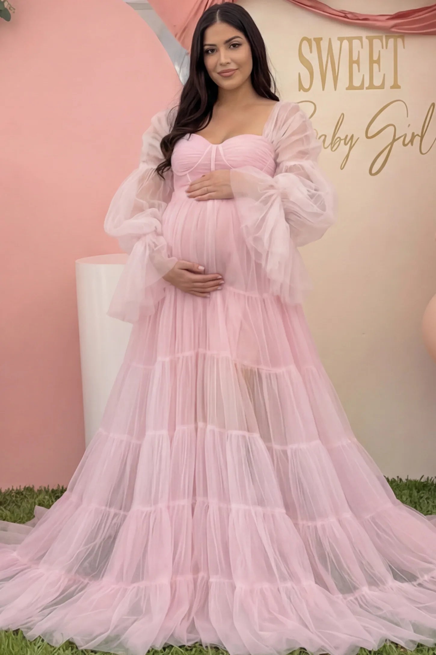 Tiered Tulle Long Sleeve Maternity photoshoot Gown in Pink featuring a sweetheart neckline and voluminous tulle layers on a pregnant woman in an outdoor setting, front view.