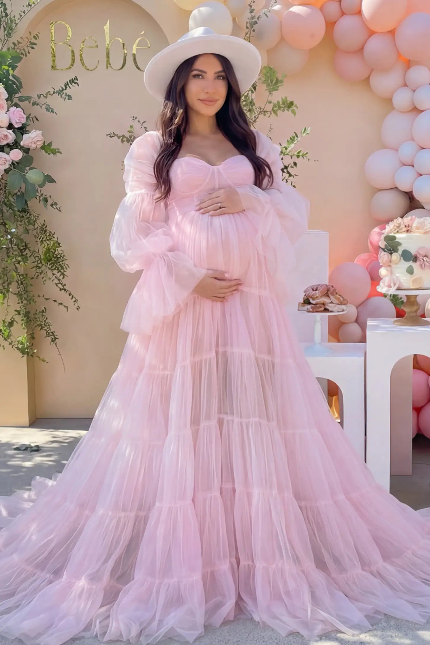 Tiered Tulle Long Sleeve Maternity Photoshoot Gown Tiered Tulle Long Sleeve Maternity photoshoot Gown in Pink featuring a sweetheart neckline and voluminous tulle layers on a pregnant woman in an outdoor setting, front view.