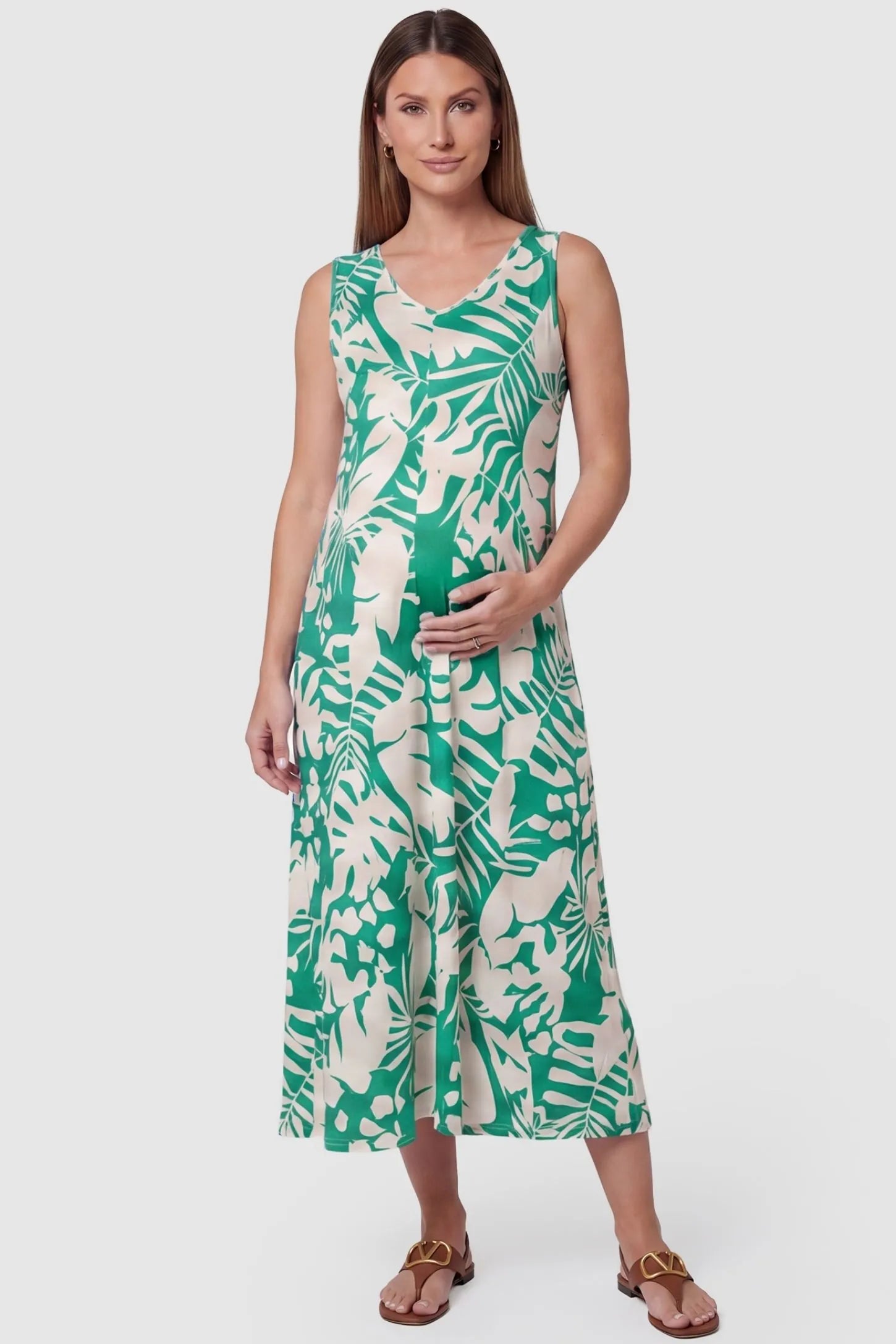 Tropical Print Sleeveless Midi Maternity Dress Tropical Print Sleeveless Midi Maternity Dress in Green featuring a flattering V-neckline on a pregnant model, front view.