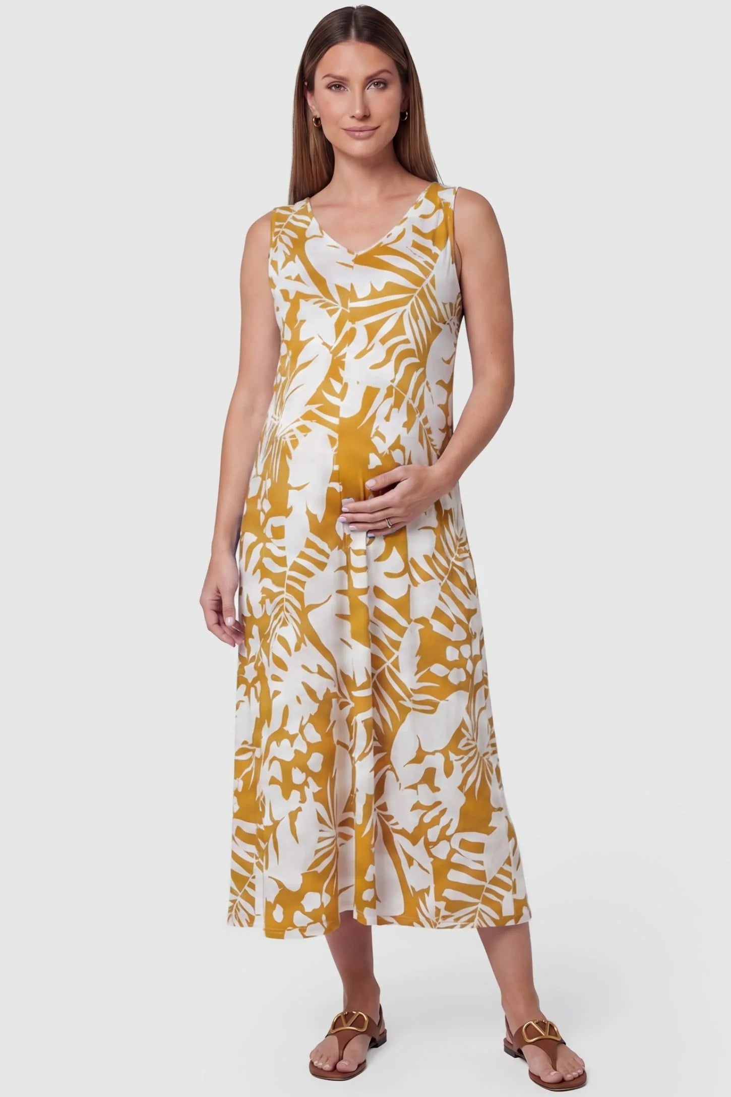 Tropical Print Sleeveless Midi Maternity Dress Tropical Print Sleeveless Midi Maternity Dress in Orange featuring a flattering V-neckline on a pregnant model, front view.