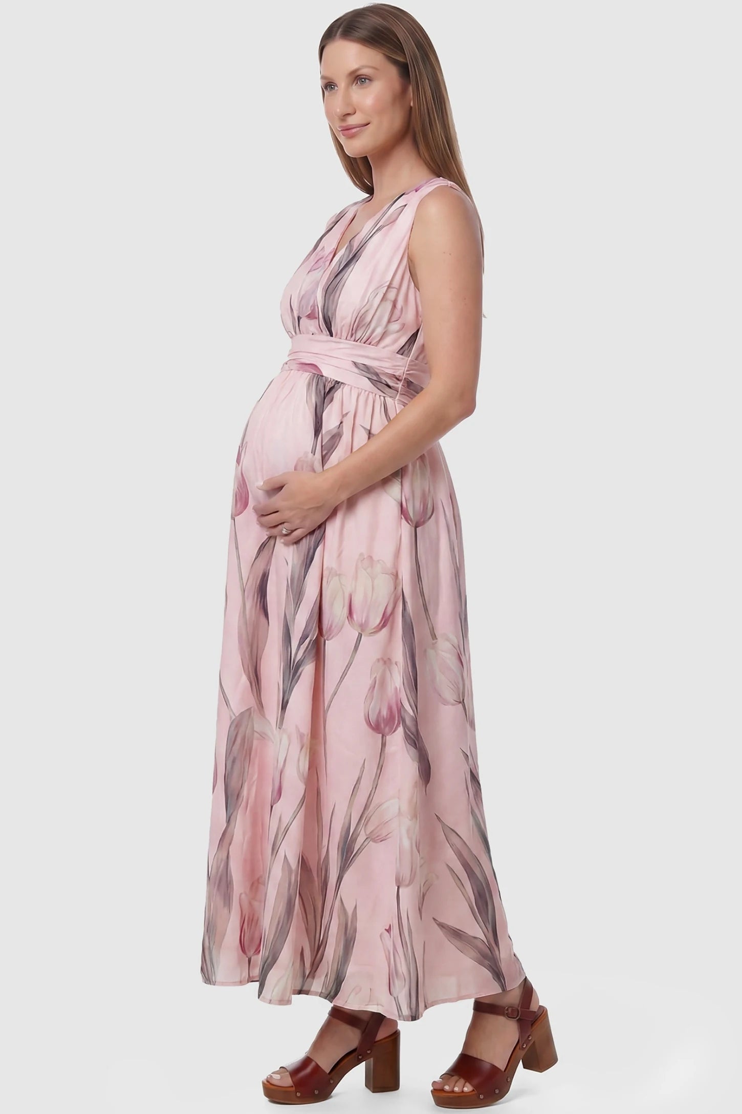 Tulip Print V-Neck Maxi Dress Tulip Print V-Neck Maxi Dress in Pink featuring a soft watercolor tulip print on a pregnant model, side view.