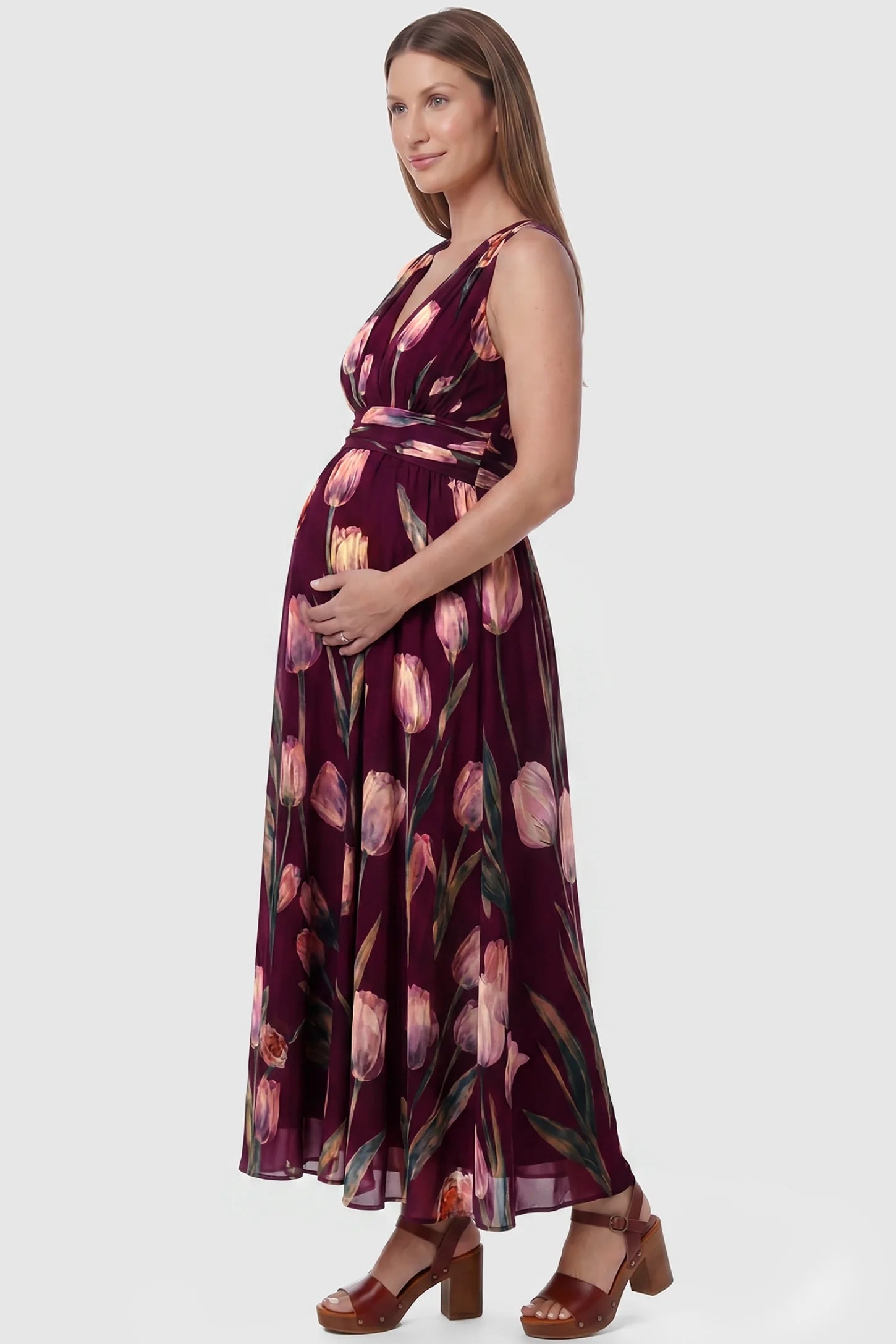 Tulip Print V-Neck Maxi Dress Tulip Print V-Neck Maxi Dress in Wine Red featuring a vibrant tulip floral print on a pregnant model, side view.