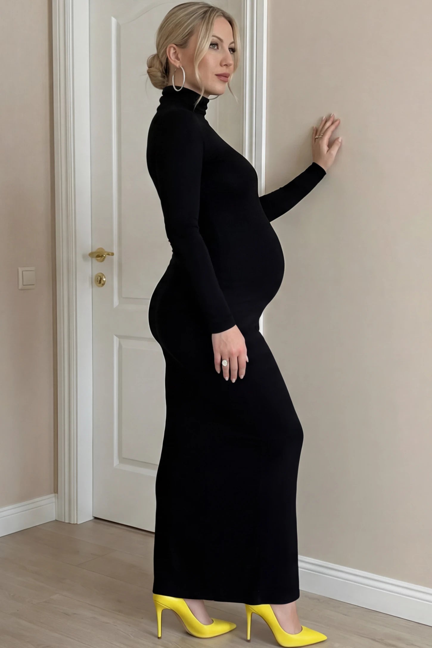Turtle Neck Long Sleeve Maternity Maxi Dress Turtle Neck Long Sleeve Maternity Maxi Dress in Black featuring a turtleneck and long sleeves on a pregnant woman, side view.