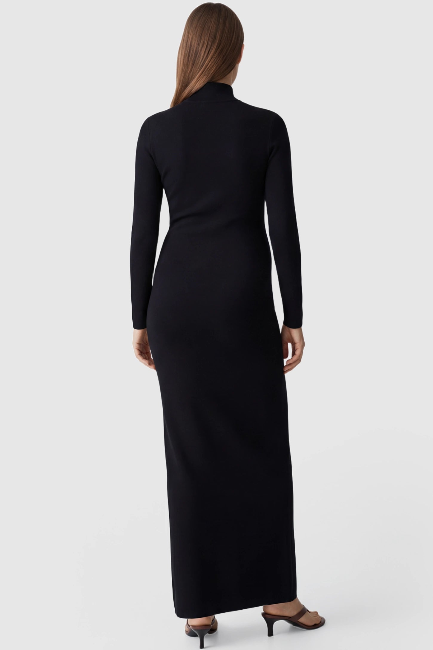 Turtle Neck Long Sleeve Maternity Maxi Dress Turtle Neck Long Sleeve Maternity Maxi Dress in Black featuring a sleek floor-length silhouette and long sleeves on a pregnant model, back view.