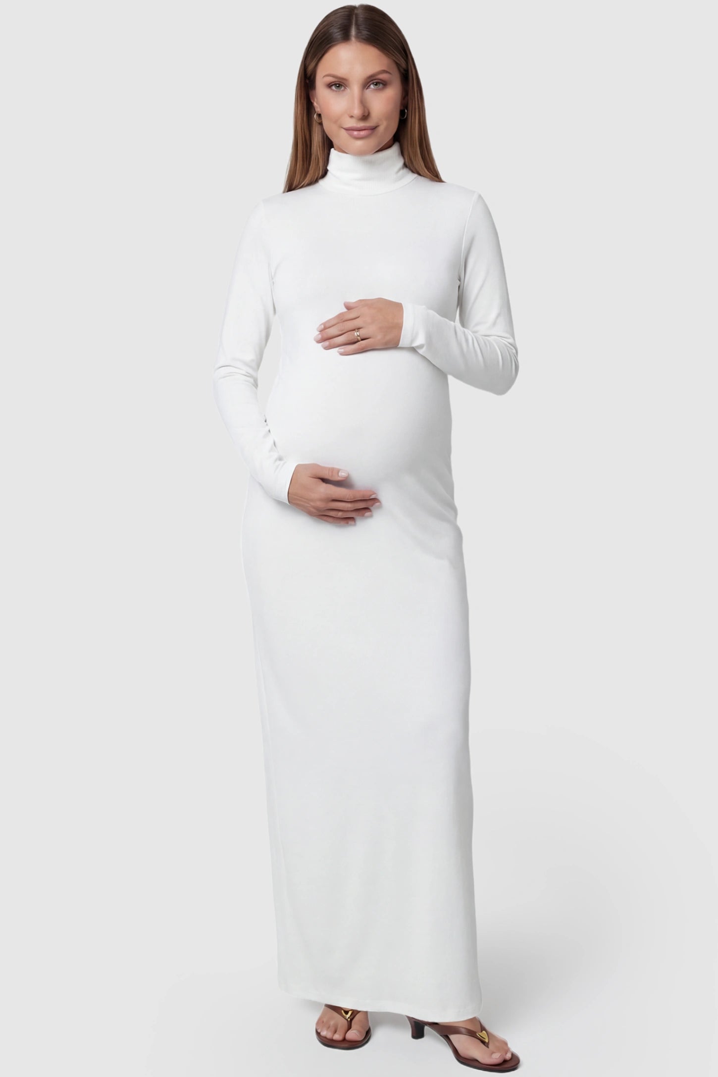Turtle Neck Long Sleeve Maternity Maxi Dress Turtle Neck Long Sleeve Maternity Maxi Dress in White featuring a turtleneck and long sleeves on a pregnant model, front view.