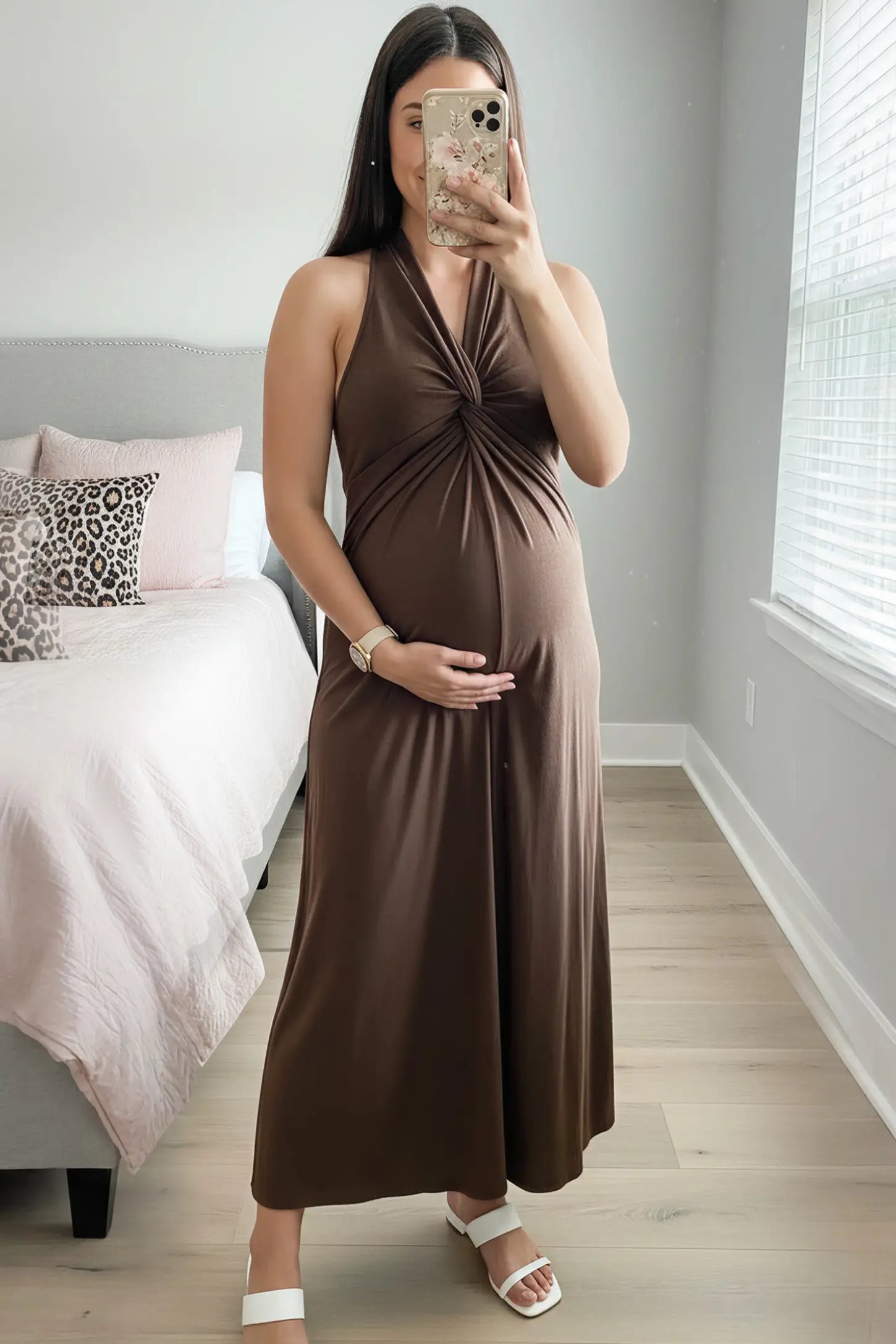 Twist Front Halter Neck Maternity Maxi Dress Twist Front Halter Neck Maternity Maxi Dress in Coffee featuring knot detail, sleeveless, A-line silhouette on a pregnant woman, front view.