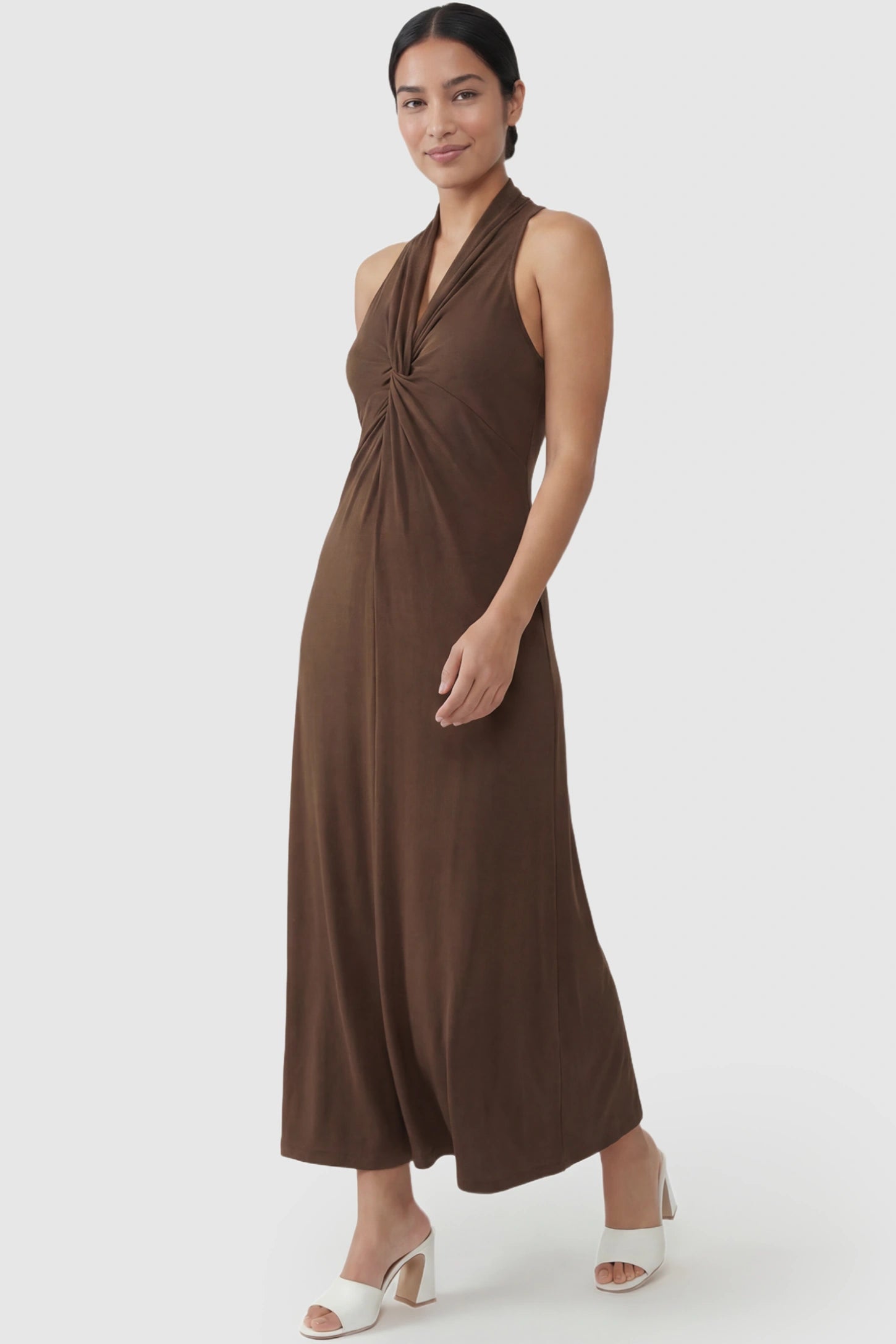 Twist Front Halter Neck Maternity Maxi Dress Twist Front Halter Neck Maternity Maxi Dress in Coffee featuring knot detail, sleeveless, A-line silhouette on a postpartum model, front view.