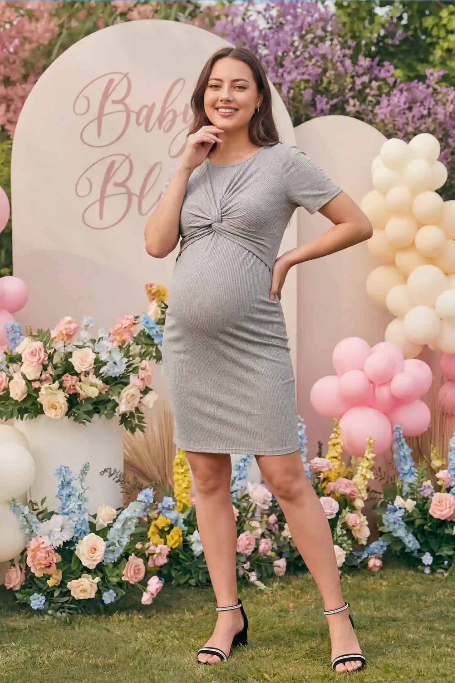 Twist Front Round Neck Short Sleeve Maternity Short Dress Twist Front Round Neck Maternity Short Dress in gray featuring side ruched panels on a pregnant model model in a room, front view.