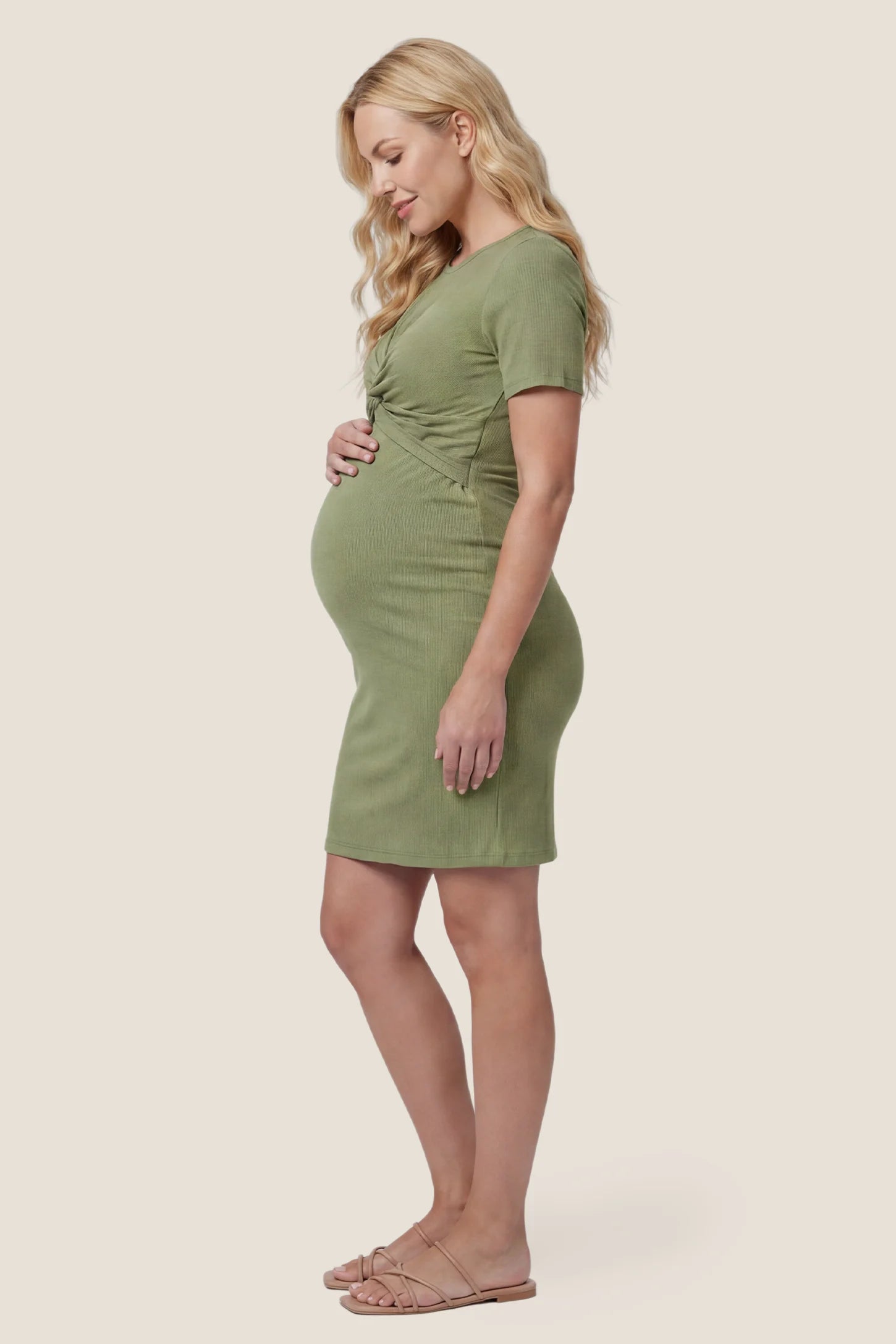 Twist Front Round Neck Short Sleeve Maternity Short Dress Twist Front Round Neck Maternity Short Dress in green featuring side ruched panels on a pregnant model, side view.