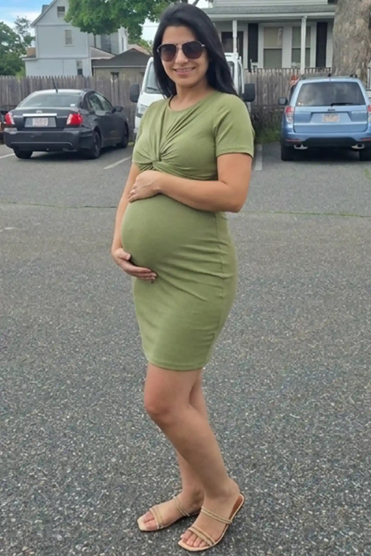Twist Front Round Neck Short Sleeve Maternity Short Dress Twist Front Round Neck Maternity Short Dress in green featuring side ruched panels on a pregnant woman in outdoor setting, side view.