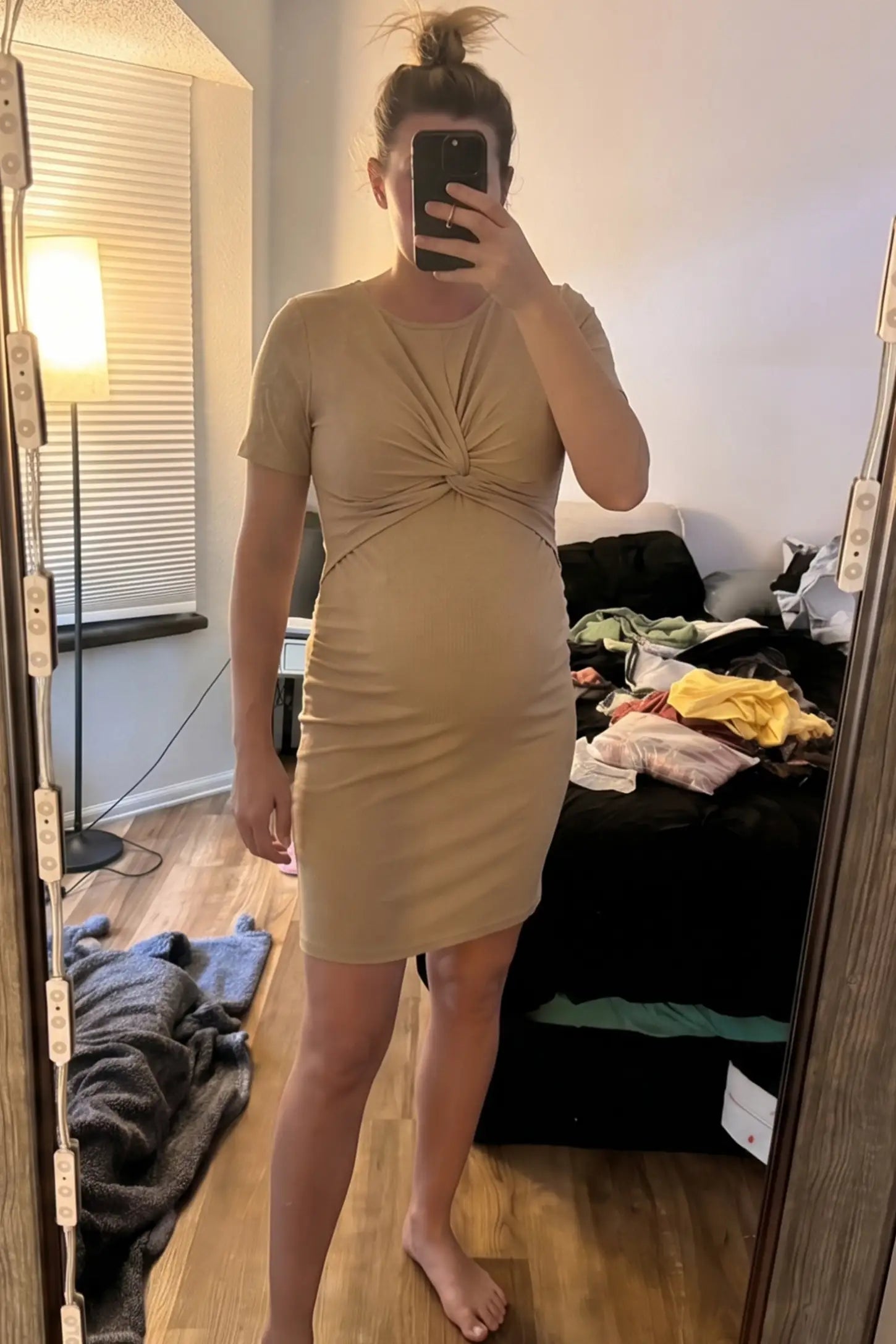 Twist Front Round Neck Short Sleeve Maternity Short Dress Twist Front Round Neck Maternity Short Dress in khaki featuring side ruched panels on a pregnant woman in indoor setting, front view.