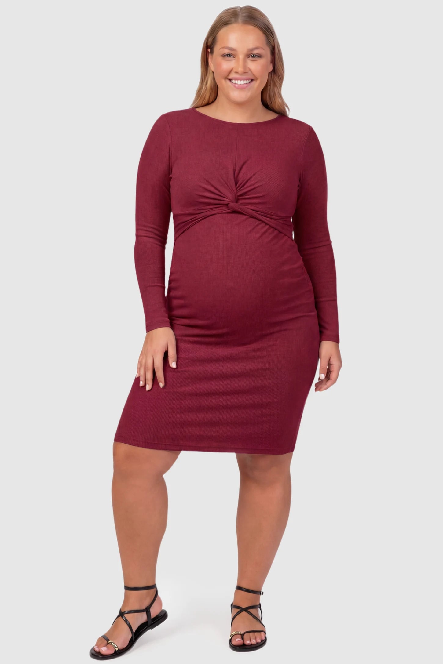 Twist Front Round Neck Short Sleeve Maternity Short Dress Twist Front Round Neck Maternity Short Dress in wine red featuring side ruched panels on a plus size pregnant model, front view.