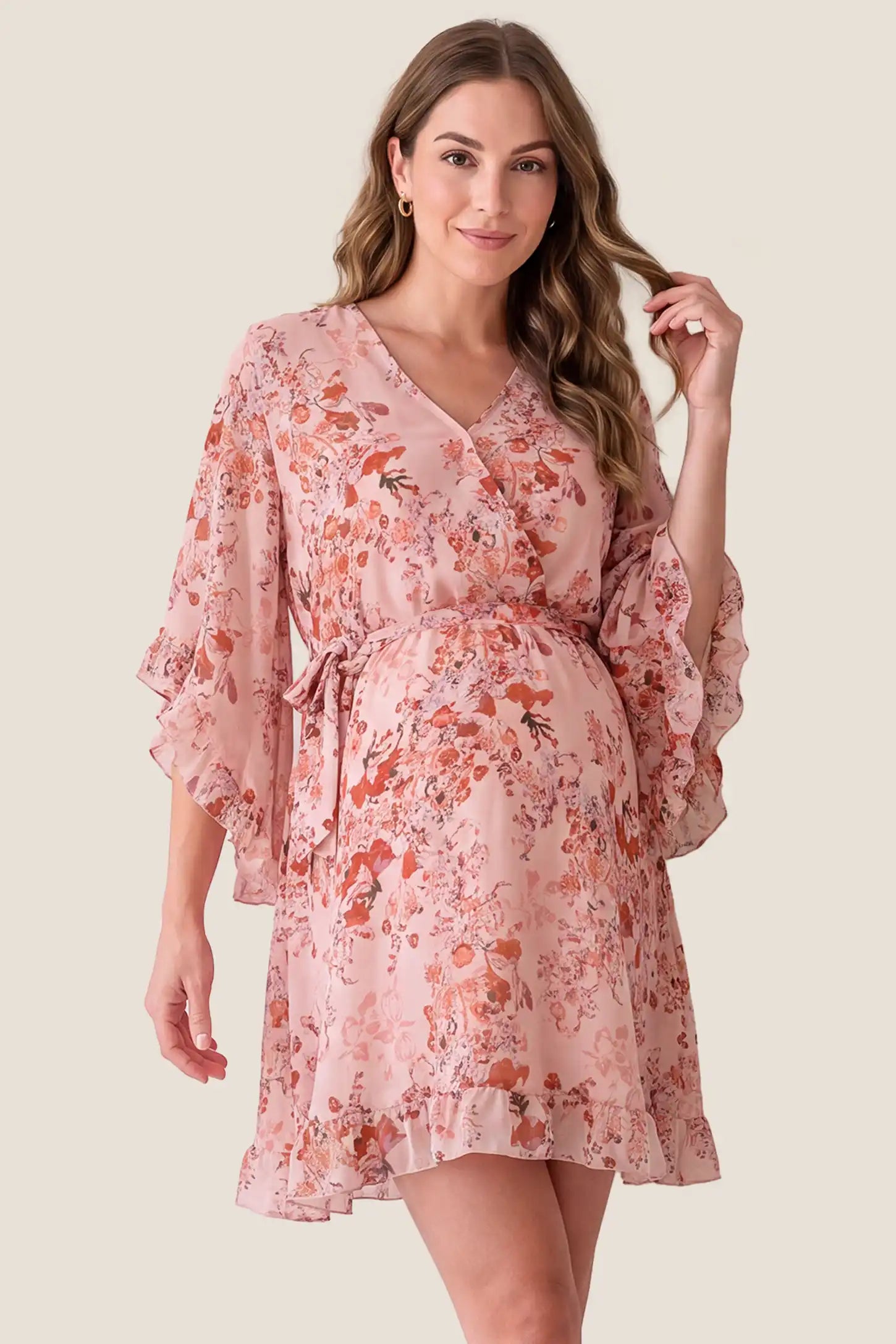 V-Neck Bell Sleeve Long Sleeve Maternity Dress V-Neck Bell Sleeve Long Sleeve Maternity Dress in Blush Floral on a pregnant model, studio front view.