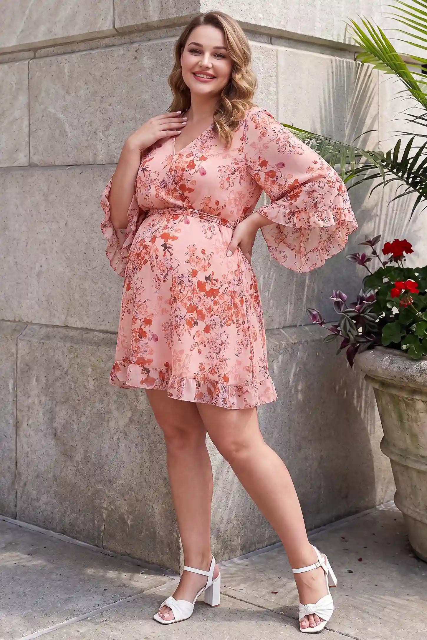 V-Neck Bell Sleeve Long Sleeve Maternity Dress V-Neck Bell Sleeve Long Sleeve Maternity Dress in Blush Floral featuring long bell sleeves on a pregnant model, lifestyle front view.