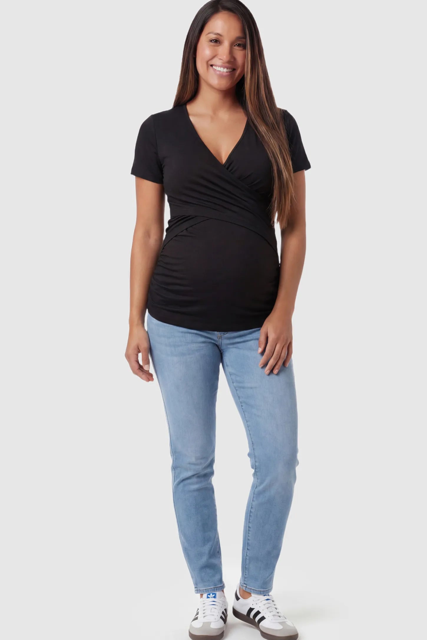 V Neck Crossover Maternity & Nursing Top Cross-Front Maternity and Nursing Top in Black featuring moisture-wicking fabric and wrap nursing access on a pregnant model showing front.