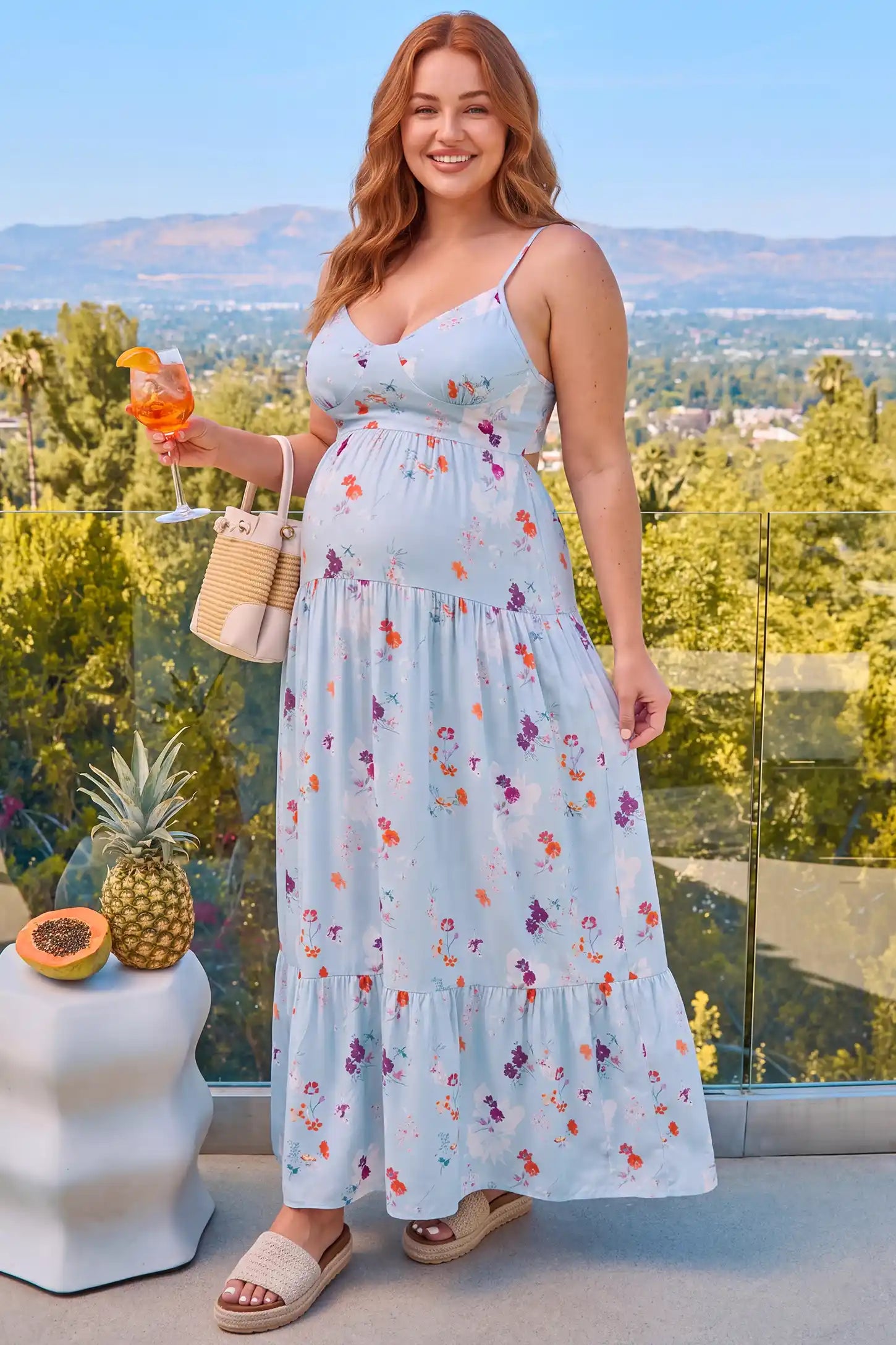 V-Neck Open Back Maternity Maxi Dress V-Neck Open Back Maternity Maxi Dress in Light Blue Floral featuring a flattering flowy fit, lifestyle view on a plus-size model.