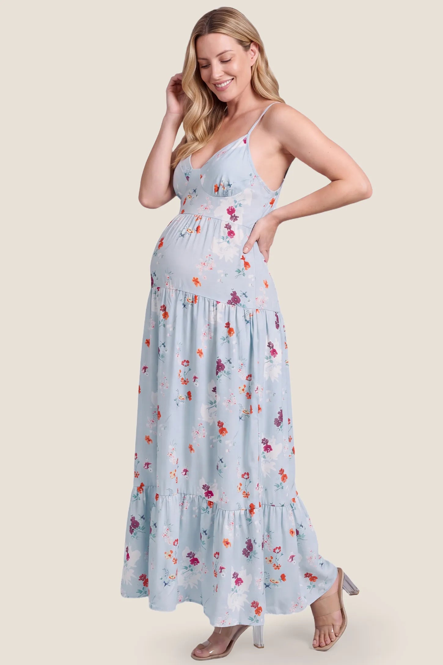 V-Neck Open Back Maternity Maxi Dress V-Neck Open Back Maternity Maxi Dress in Light Blue Floral showing the comfortable drape over the bump on a pregnant model, studio side view.
