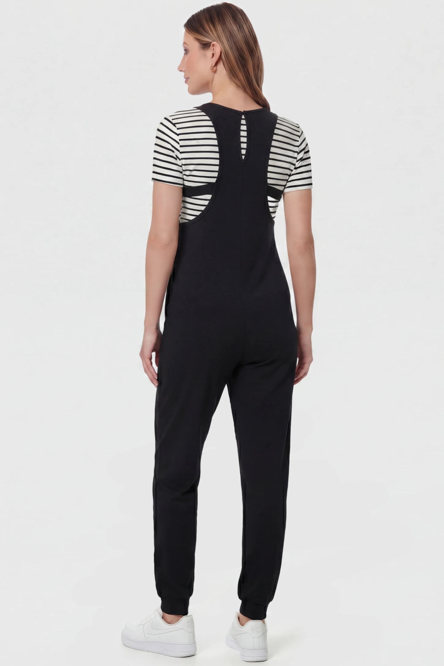 V-Neck Pocketed Maternity Jogger Jumpsuit V-Neck Pocketed Maternity Jogger Jumpsuit in Black featuring cotton-spandex jersey on a pregnant model, back view.