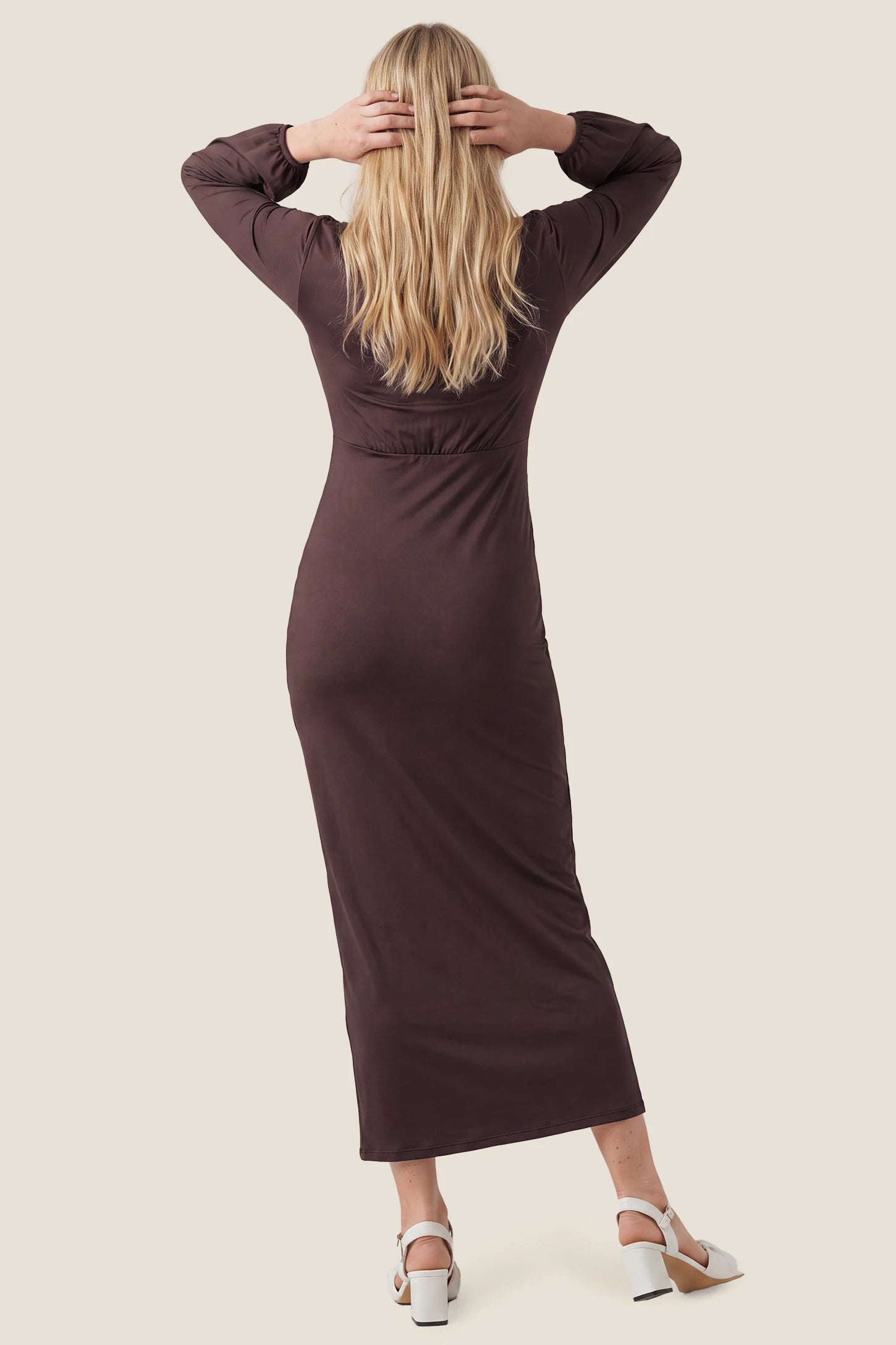 V-Neck Ruched Long Sleeve Maternity Midi Dress V-Neck Ruched Long Sleeve Maternity Midi Dress in Brown highlighting the sleek back silhouette and long sleeves, back view on a pregnant model.