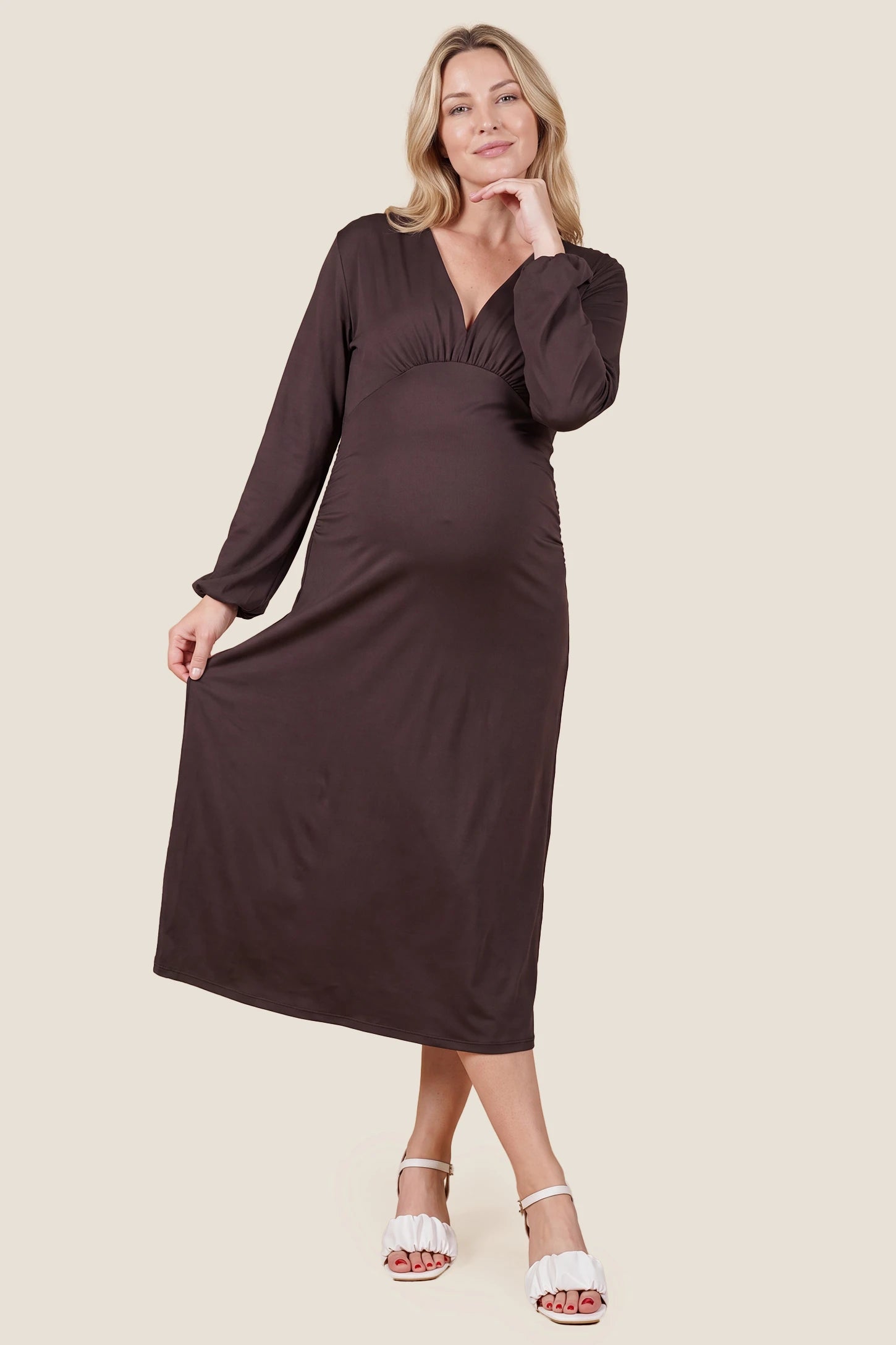 V-Neck Ruched Long Sleeve Maternity Midi Dress V-Neck Ruched Long Sleeve Maternity Midi Dress in Brown featuring a classic V-neckline and flattering side ruching, front view on a pregnant model.