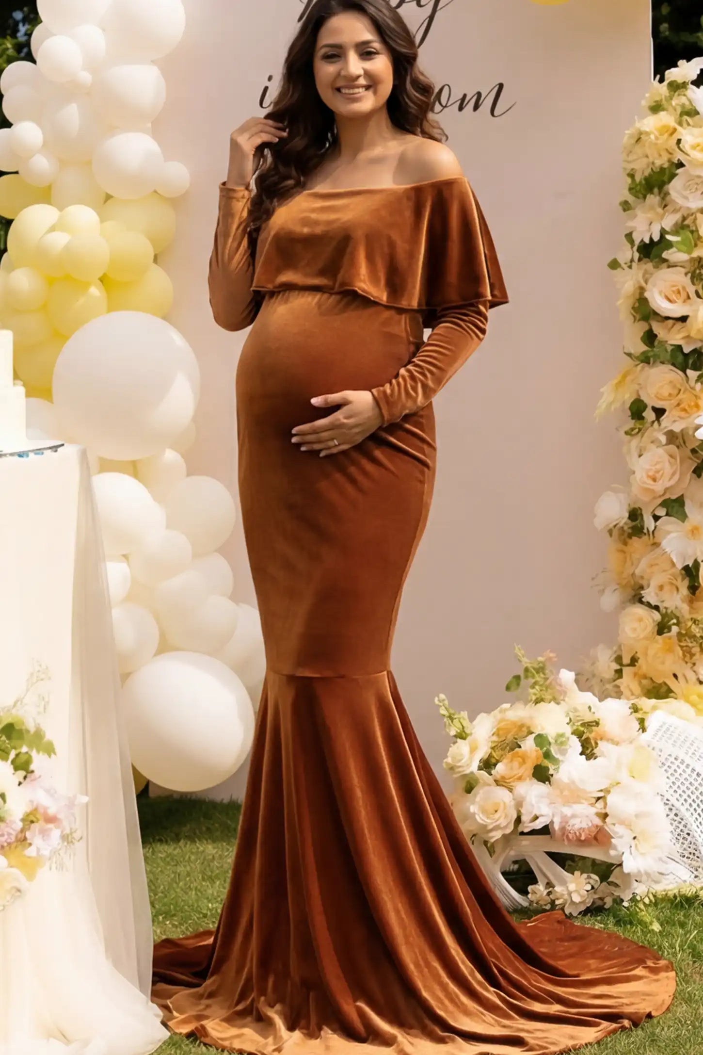 Velvet Off Shoulder Long Sleeve Maternity Mermaid Gown Velvet Off-the-Shoulder Maternity Mermaid Gown in Brown featuring a ruffled neckline and long sleeves on a pregnant model.