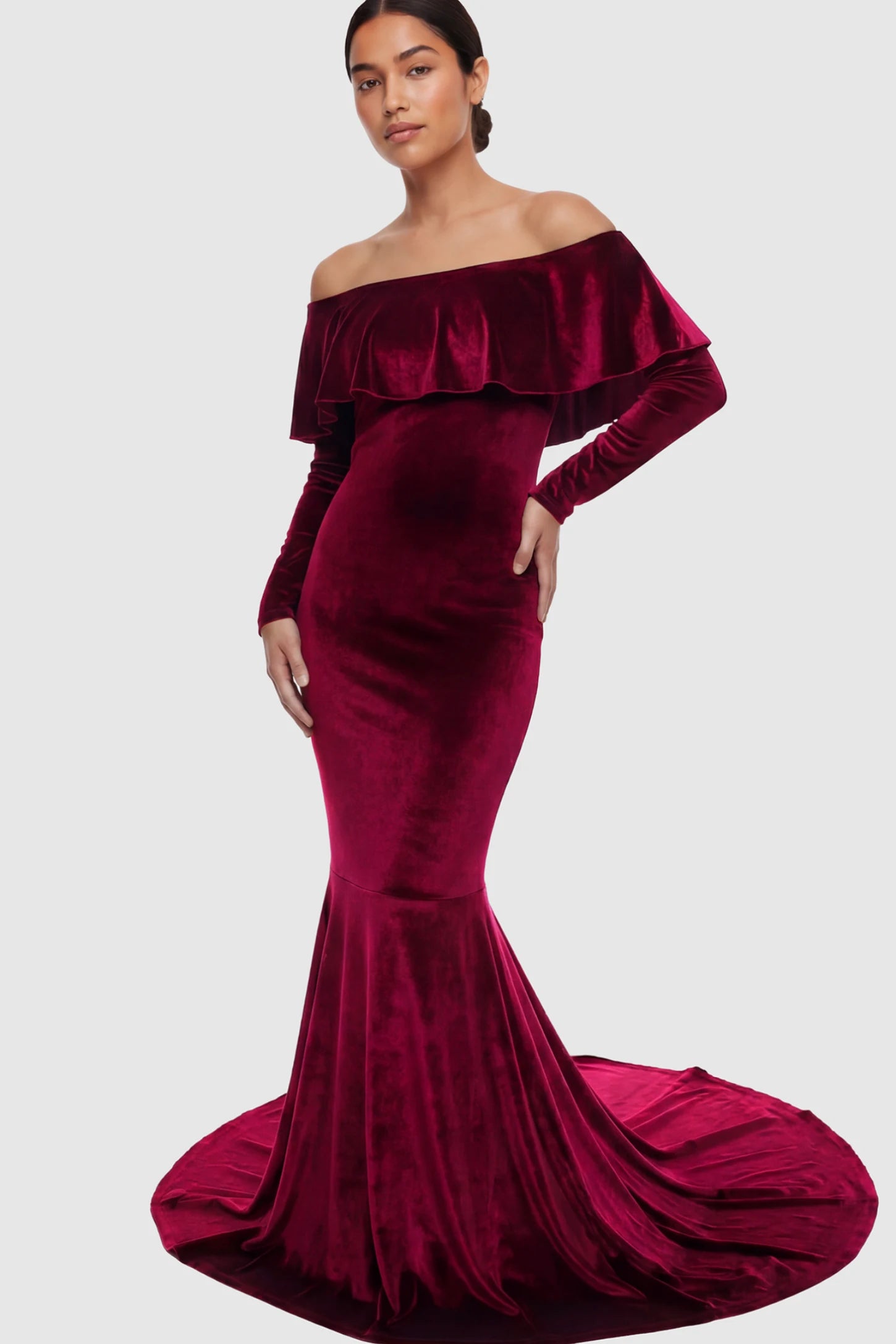Velvet Off Shoulder Long Sleeve Maternity Mermaid Gown Velvet Off-the-Shoulder Maternity Mermaid Gown in Burgundy featuring a ruffled neckline and long sleeves on a postpartum model.