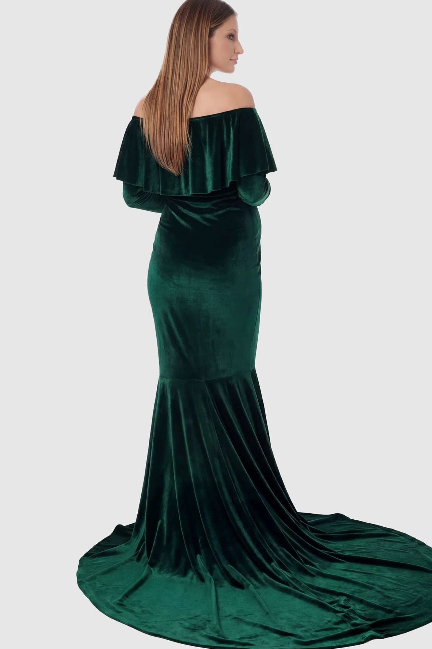 Velvet Off Shoulder Long Sleeve Maternity Mermaid Gown Velvet Off-the-Shoulder Maternity Mermaid Gown in Green featuring a ruffled neckline and long sleeves on a pregnant model showing back.