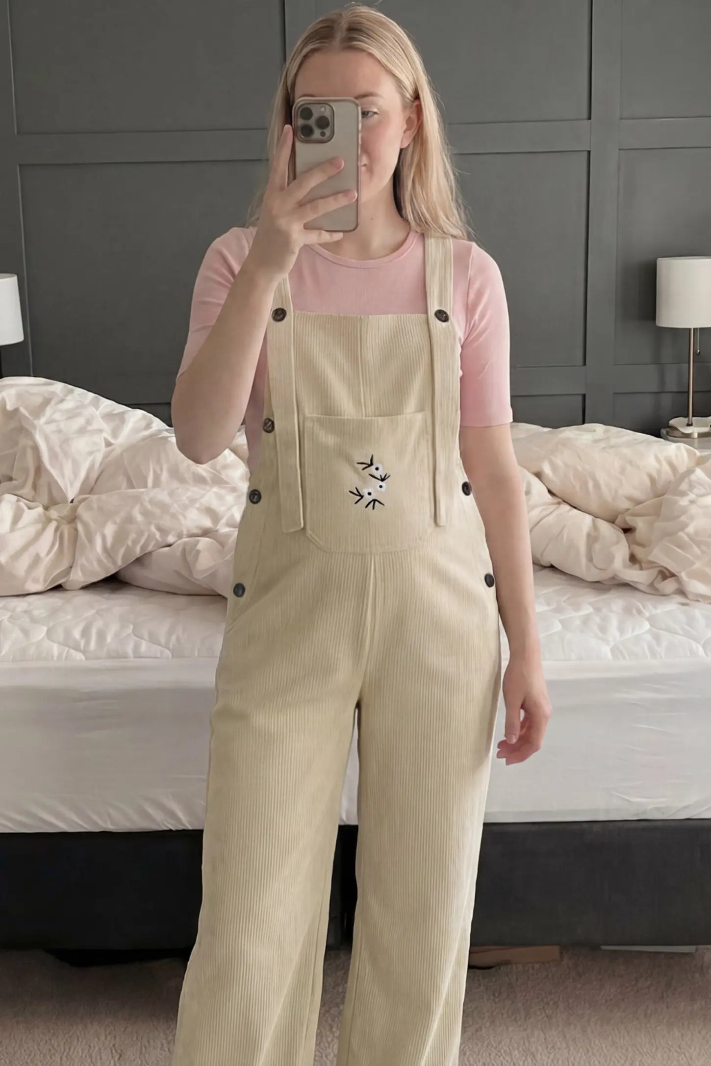 Adjustable Strap Wide-Leg Corduroy Maternity Overalls Floral Embroidered Wide-Leg Maternity Overalls in apricot featuring adjustable straps on a pregnant woman in indoor setting, front view.