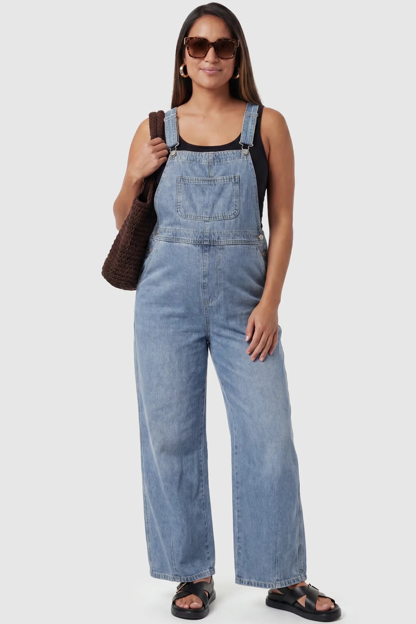 Wide Leg Relaxed Fit Maternity Overalls in light blue featuring soft washed denim on a pregnant model, front view.