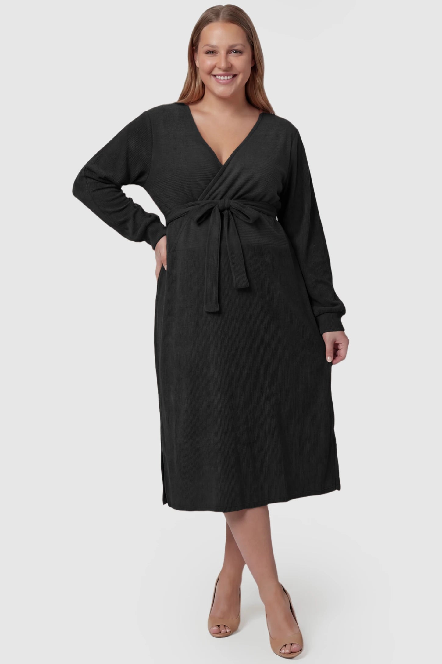 Wrap Front Tie Waist Long Sleeve Maternity Midi Dress Wrap Front Tie Waist Long Sleeve Maternity Midi Dress in Black featuring adjustable tie waist and side slits on a plus size pregnant model, front view.