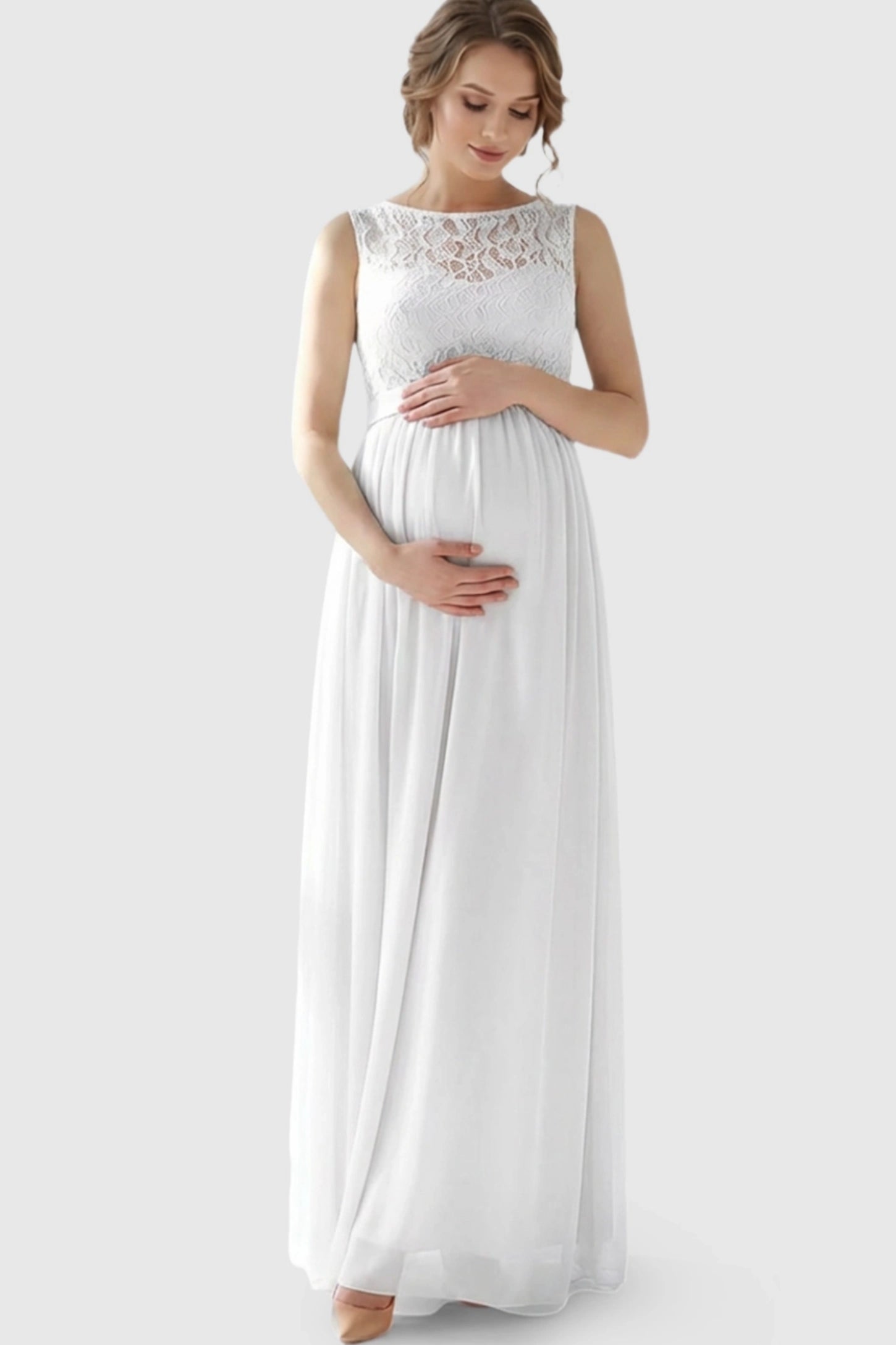 Floral Lace Sleeveless Maternity Maxi Dress Floral Lace Sleeveless Maternity Maxi Dress in White featuring a flowing skirt on a pregnant model.