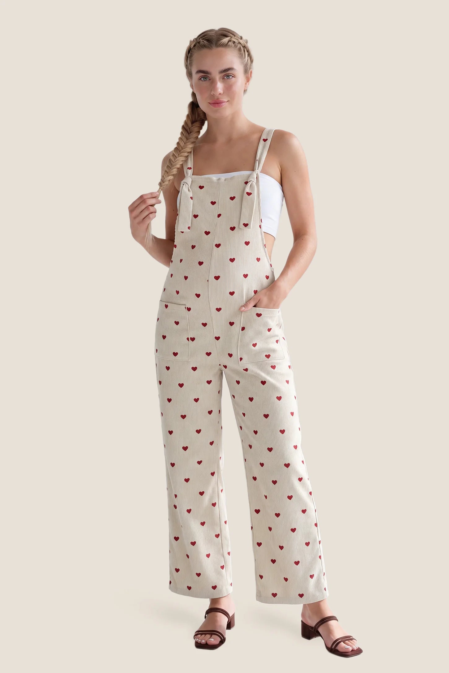 Pocketed Adjustable Maternity Overalls Model wearing Pocketed Adjustable Maternity Overalls in Oat Cherry Heart styled for postpartum wear.